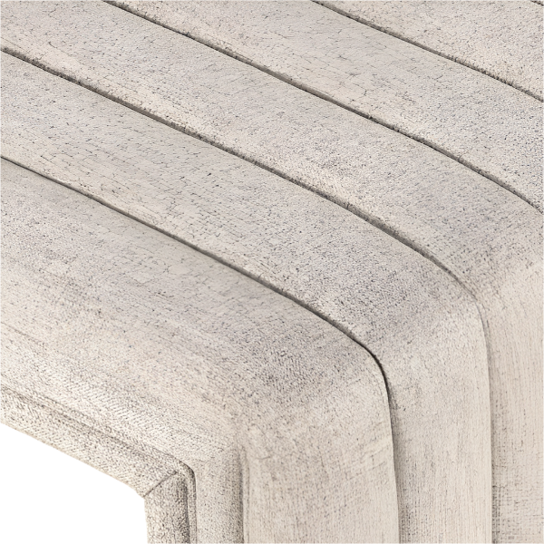Close-up of a natural beige boucle-upholstered bench seat showing a rounded corner, curved channel stitching, and textured fabric grain.