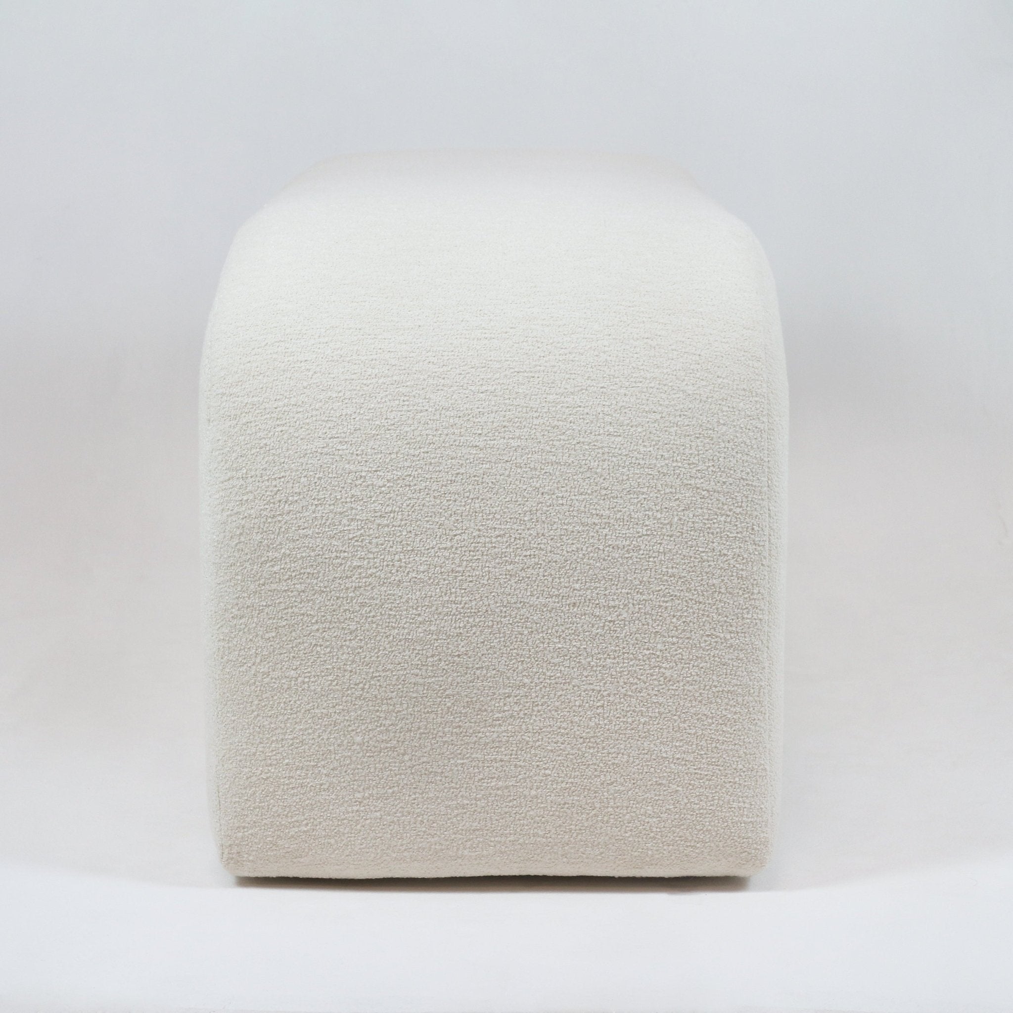 Front view of a 75-inch cream boucle upholstered end-of-bed bench with rounded edges and a seamless, minimalist silhouette on a neutral background.