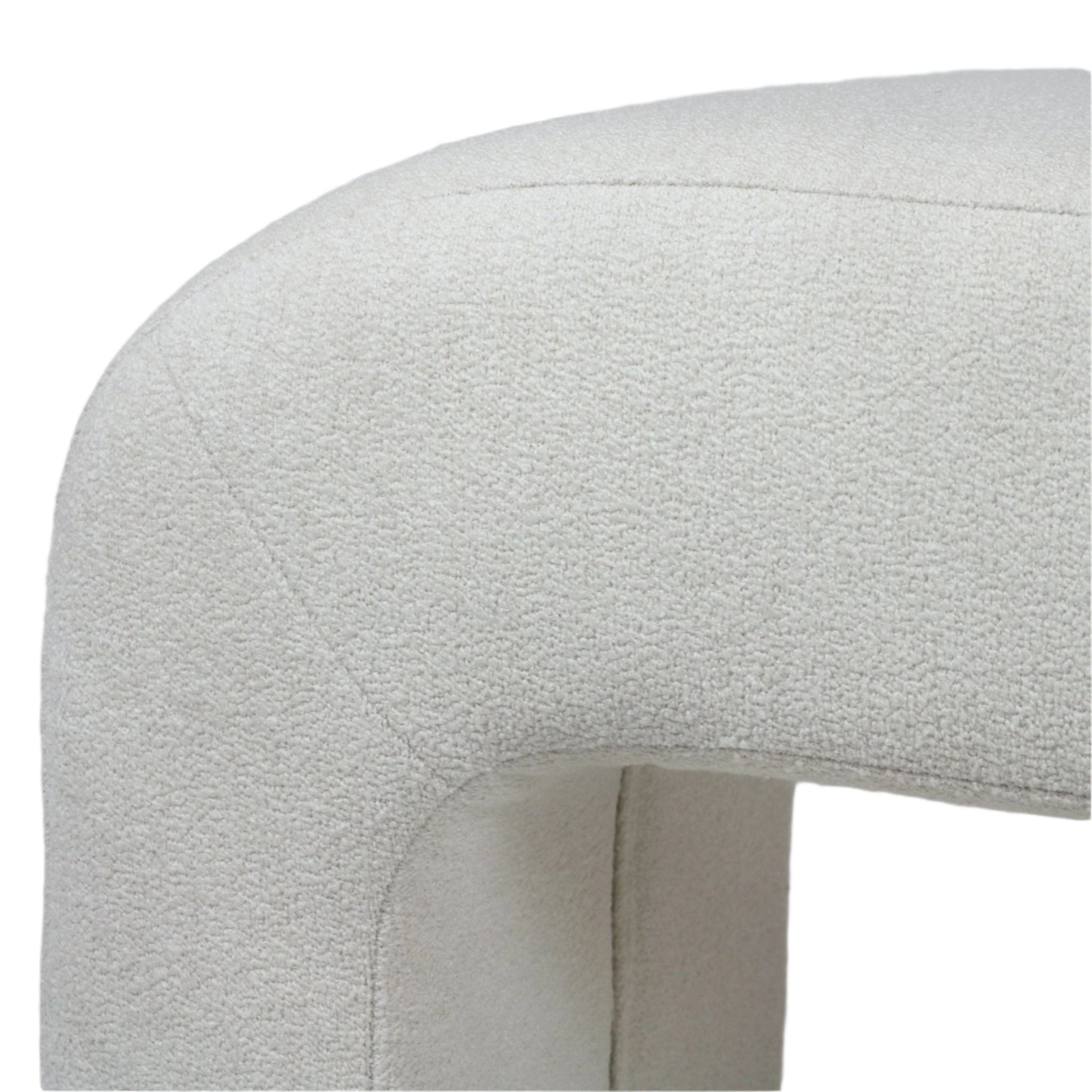 Close-up of a cream boucle upholstered end-of-bed bench corner showing a rounded silhouette, textured looped fabric and a visible seam detail.