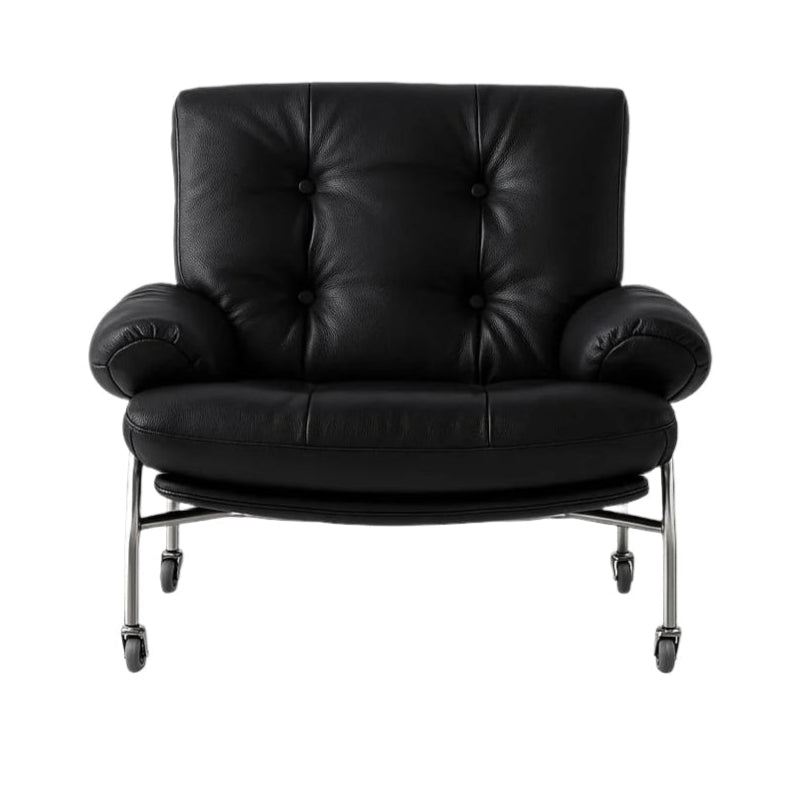 Black leather lounge chair with tufted button back, rolled arms and a curved cushioned seat supported by a chrome steel frame on caster wheels, in a modern contemporary style.