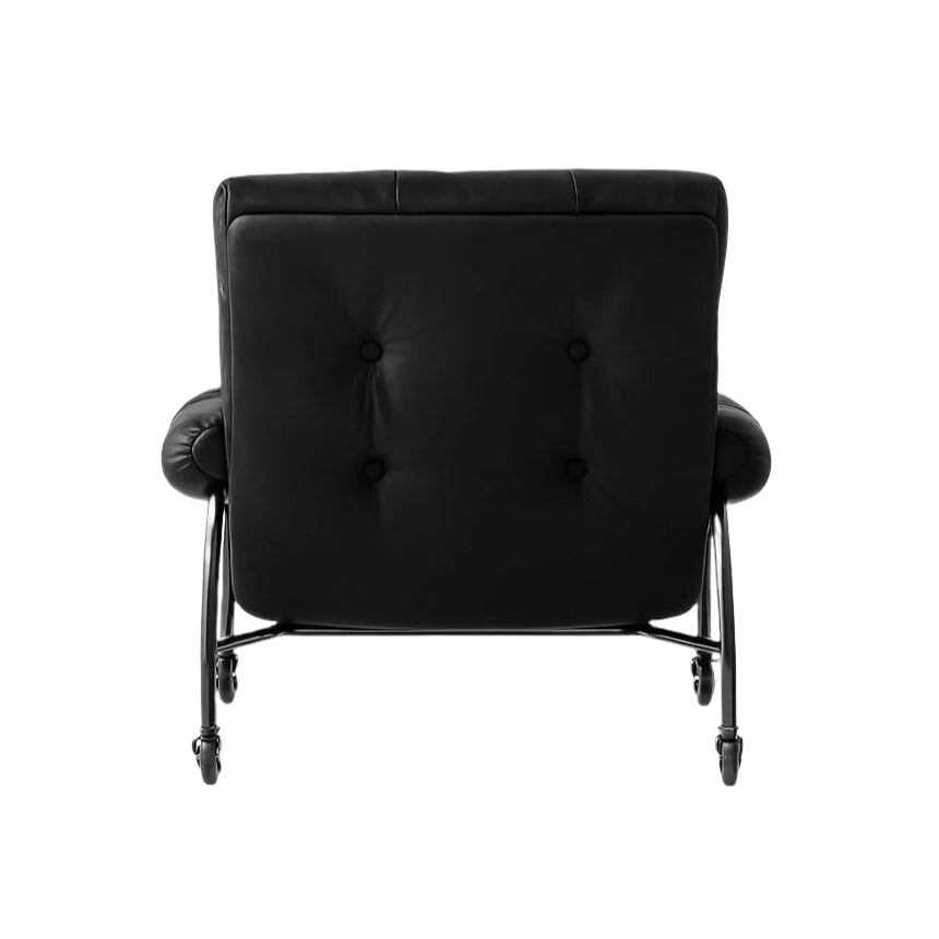 Rear view of a modern black leather lounge chair with button-tufted back, rolled arms and a chrome steel frame mounted on casters.