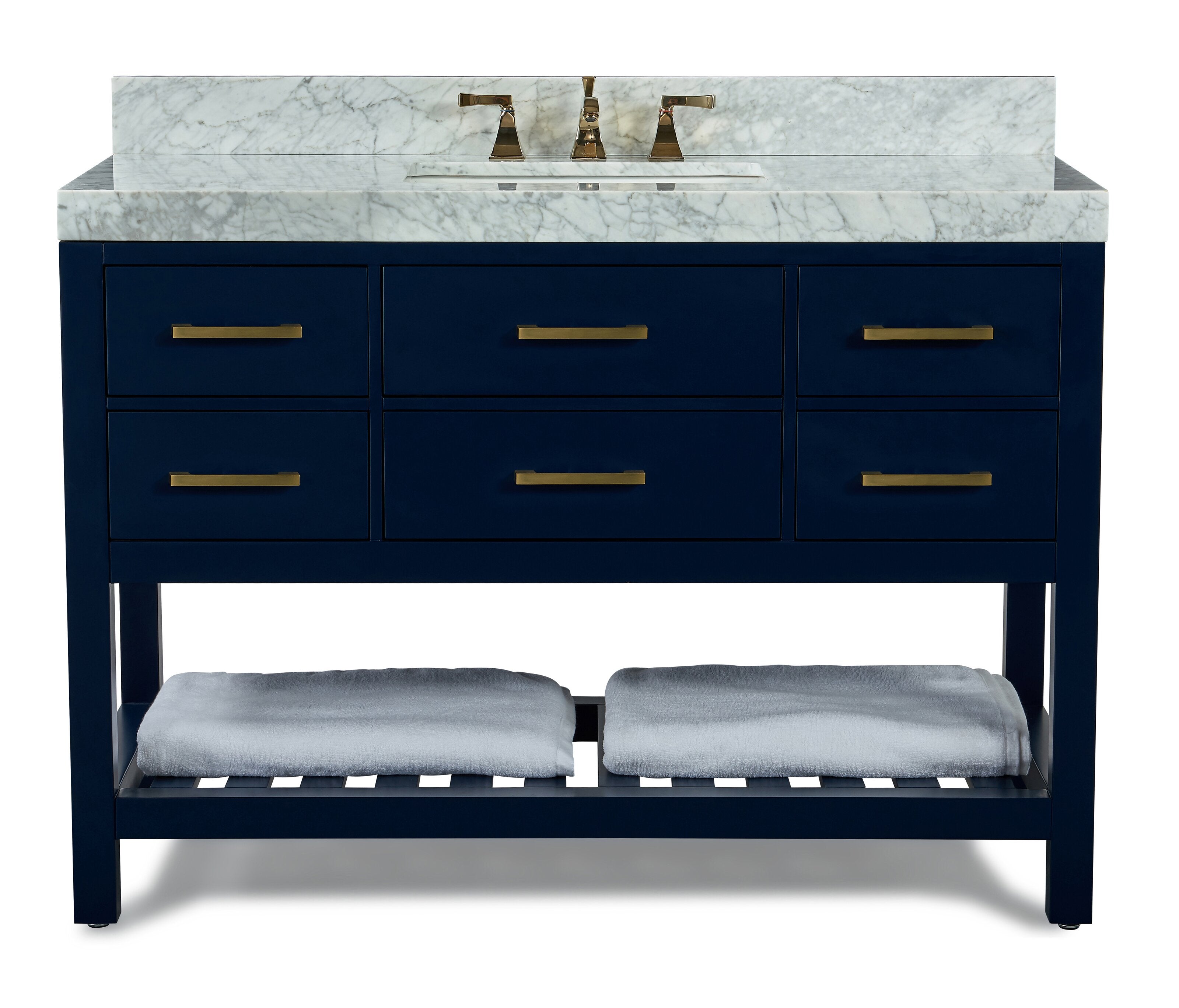 Freestanding modern navy solid-wood bathroom vanity with white veined marble top and backsplash, single rectangular undermount sink with brass faucet, six drawers with brass bar pulls and open slatted shelf holding folded gray towels.