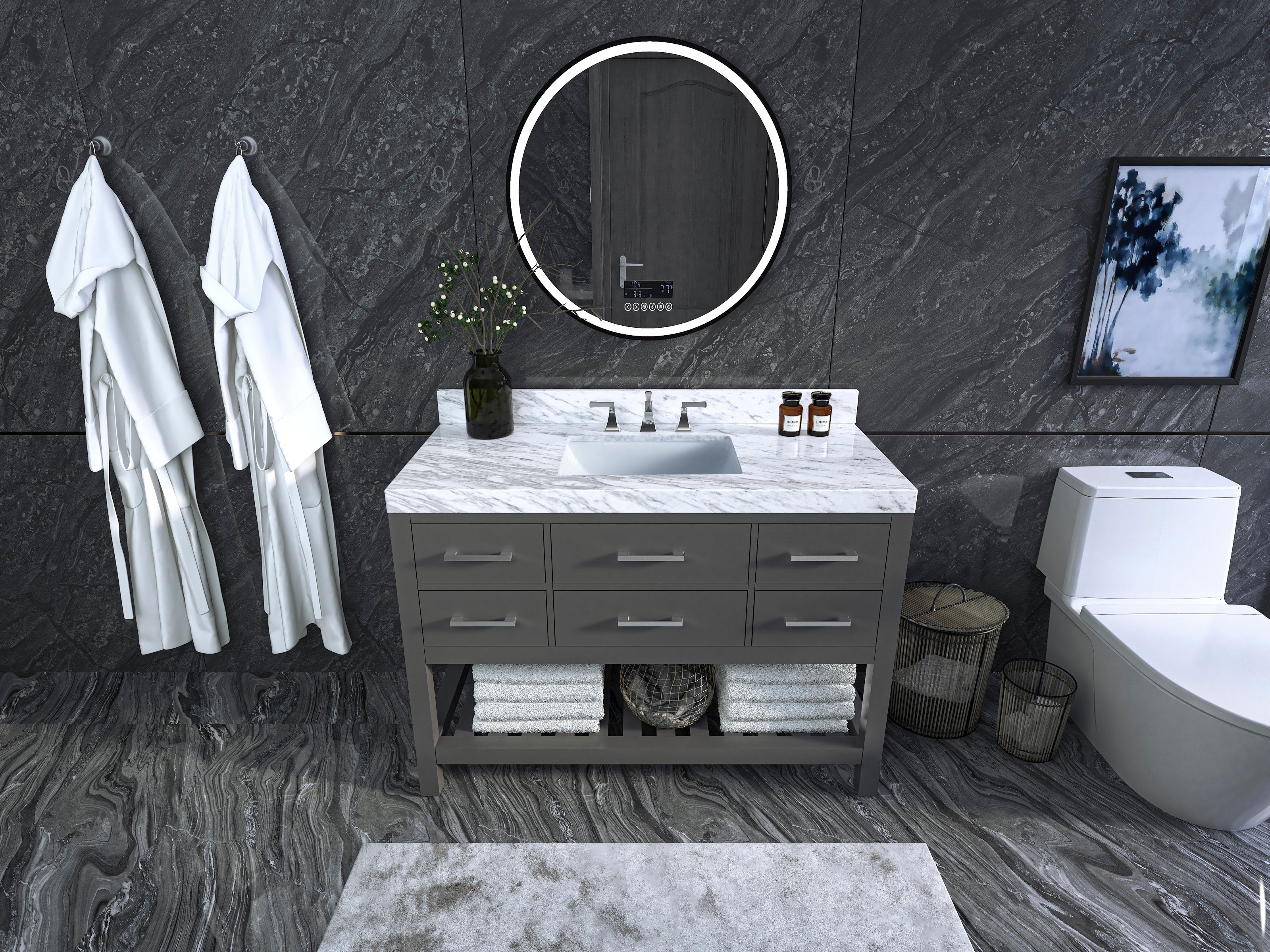 48-inch stone-colored solid wood freestanding vanity with white marble top and undermount ceramic sink, chrome faucet, round LED mirror, open towel shelf and dark stone tile walls.
