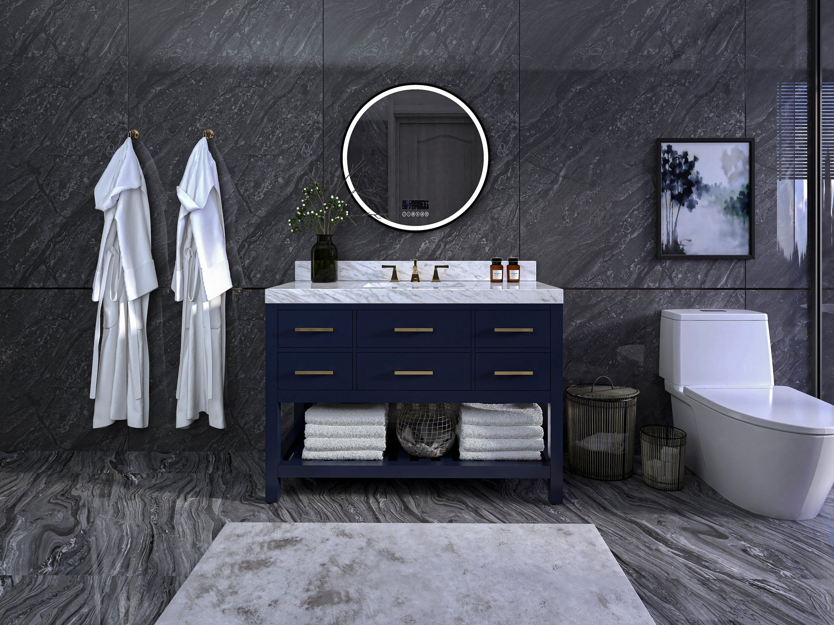 48-inch modern single-sink navy solid wood vanity with white marble top, brass handles and open lower shelf stacked with towels, set against dark stone walls with a round illuminated mirror and a white toilet to the right.