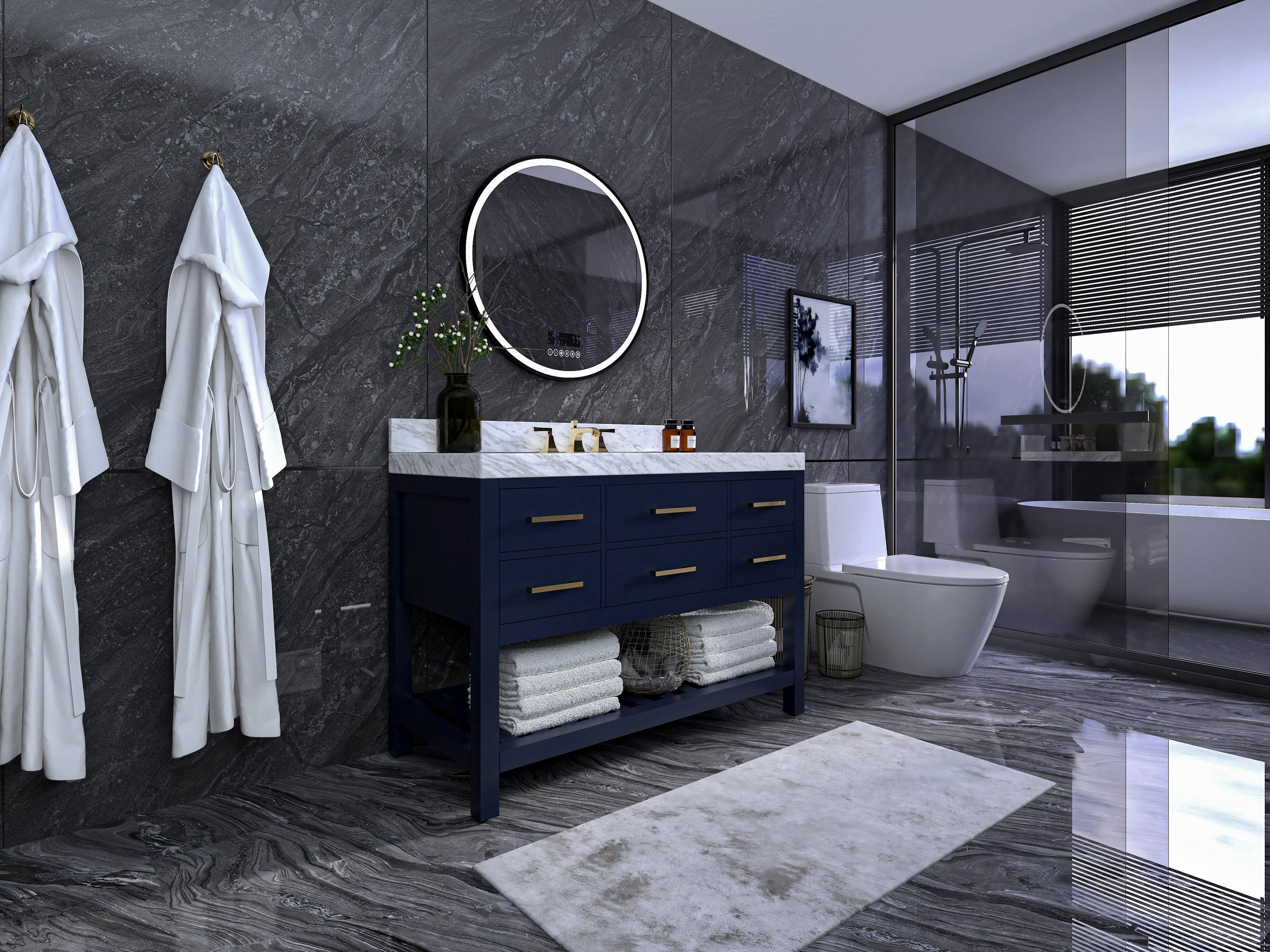 Modern freestanding navy solid-wood 48-inch vanity with white marble countertop and single ceramic sink, brass faucet and drawer pulls, open lower shelf with folded towels, round illuminated mirror and dark stone walls.