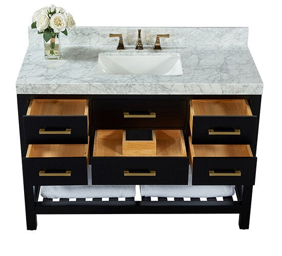 Contemporary 48-inch freestanding black solid wood vanity with stone marble top, undermount white ceramic sink, brushed gold faucet and hardware, six open drawers showing wood interiors, lower shelf with folded towels and vase of white roses.