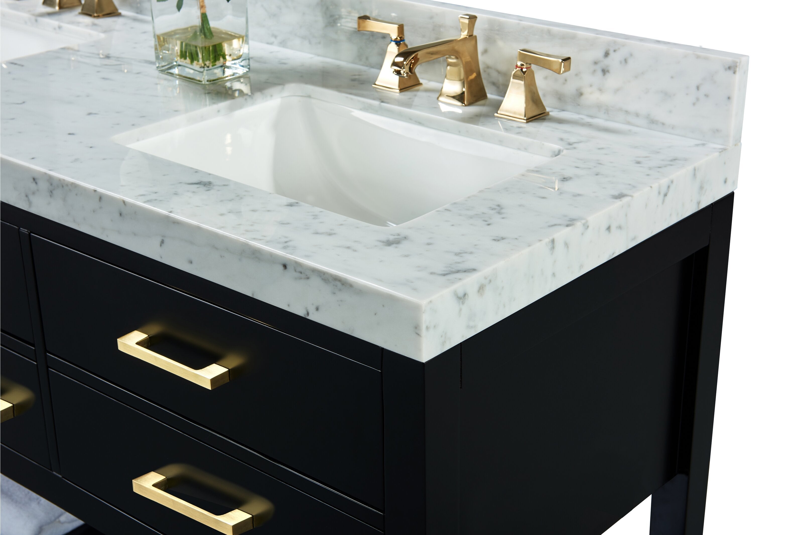 Close-up of a stone marble countertop with integrated backsplash, rectangular undermount white ceramic sink, polished brass faucet and matching brass drawer pulls on a matte black solid wood vanity.