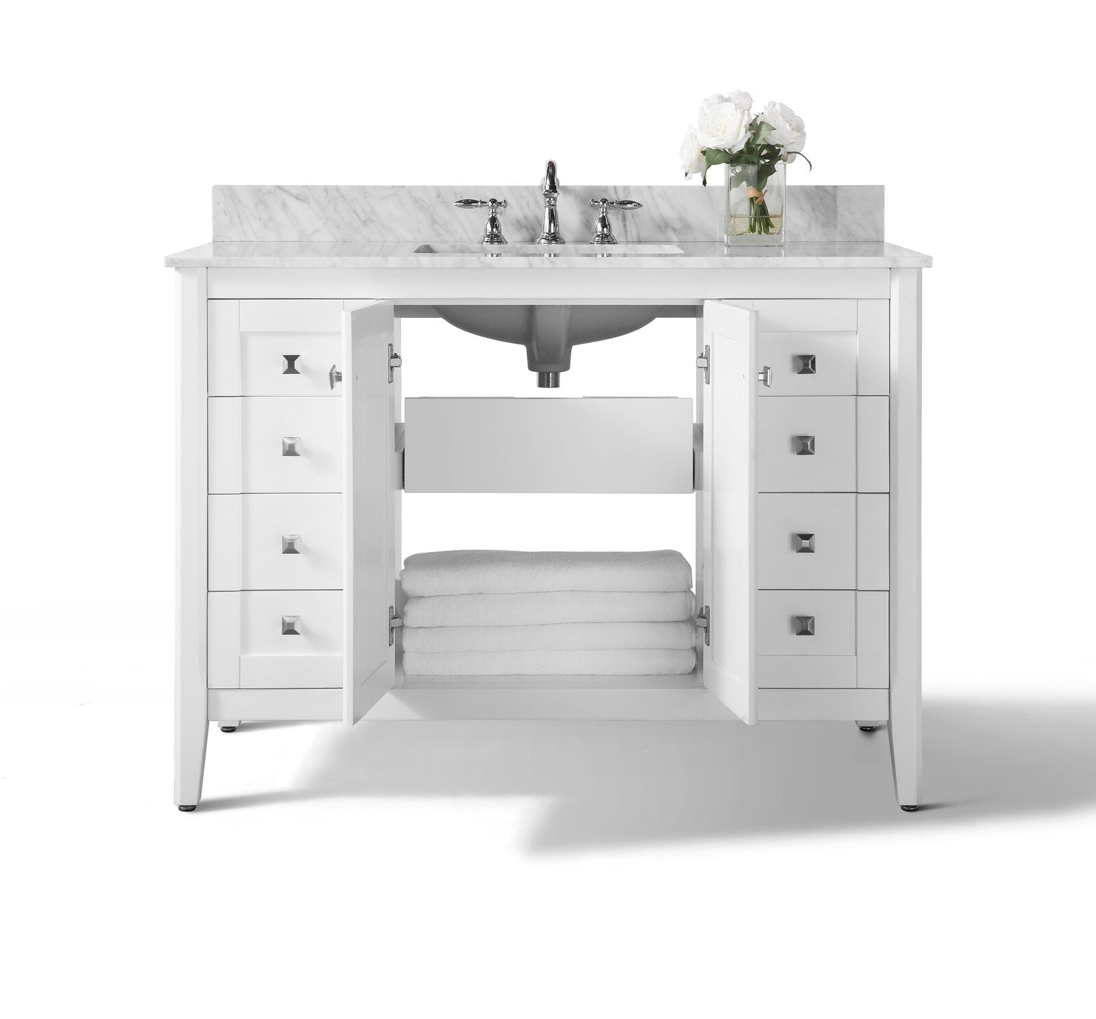 Modern white solid wood bathroom vanity with marble stone top and backsplash, single undermount sink and chrome faucet; both cabinet doors open to reveal a lower shelf with folded white towels and square metal knobs.