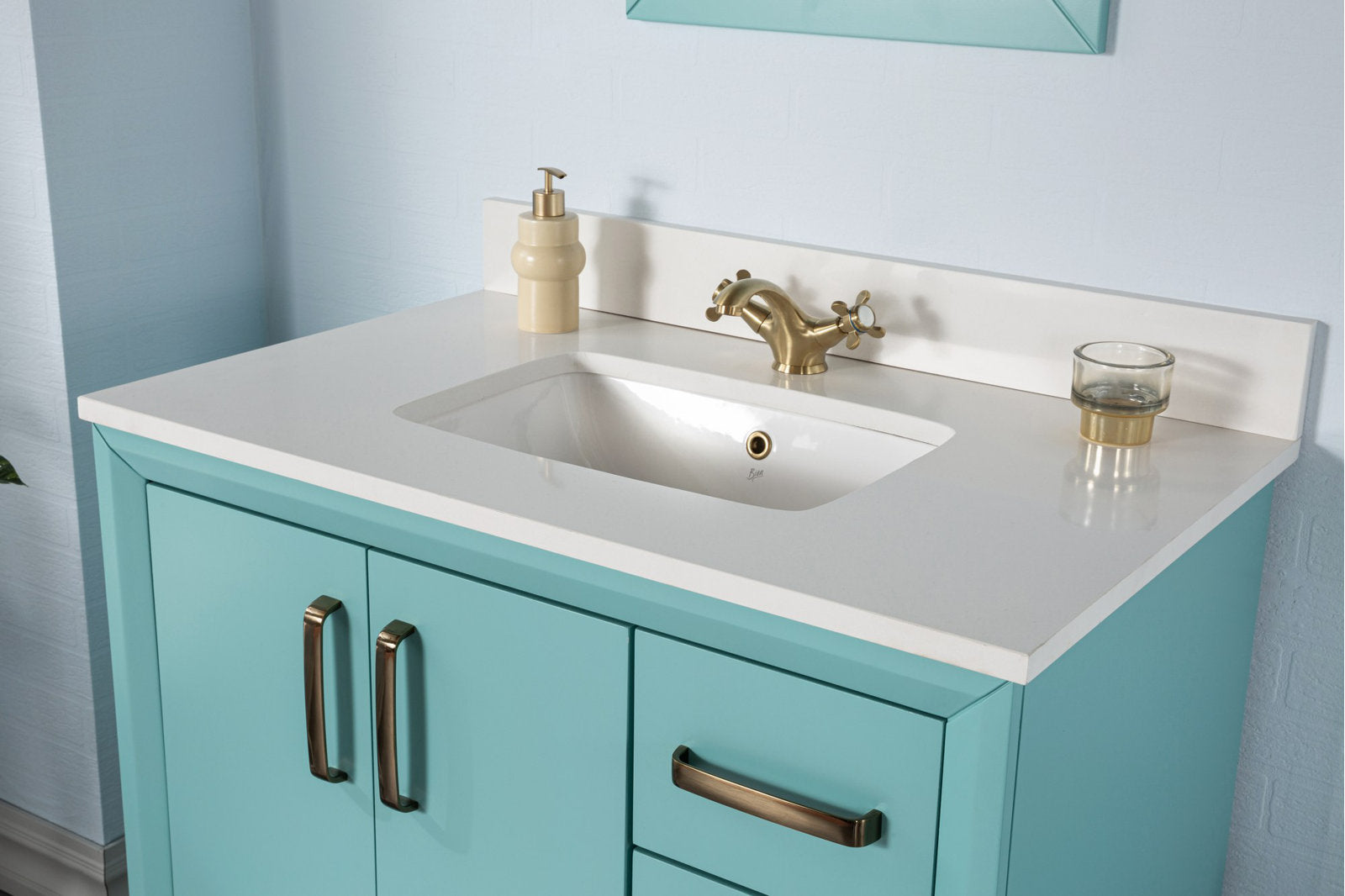 Modern turquoise solid wood bathroom vanity with a white stone countertop and integrated ceramic sink, brass cross-handle faucet and bronze-tone drawer handles.