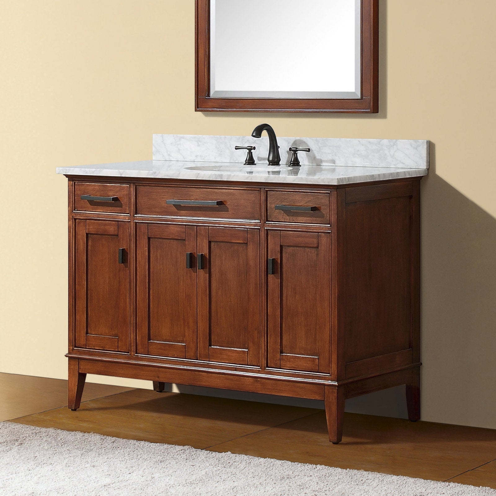 49-inch solid wood bathroom vanity in warm brown finish with white marble top and integrated single ceramic sink, matte black faucet, three top drawers and four paneled cabinet doors on tapered legs.