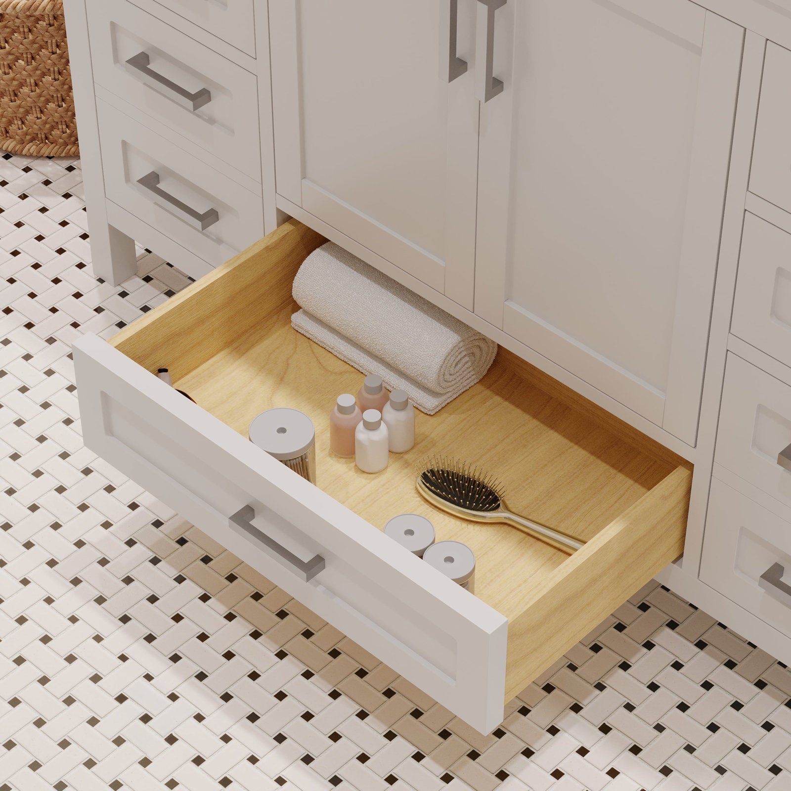 Open drawer of a stone-colored modern solid wood bathroom vanity showing a light wood interior with a rolled towel, small toiletry bottles, jars and a hairbrush on a white mosaic tile floor.