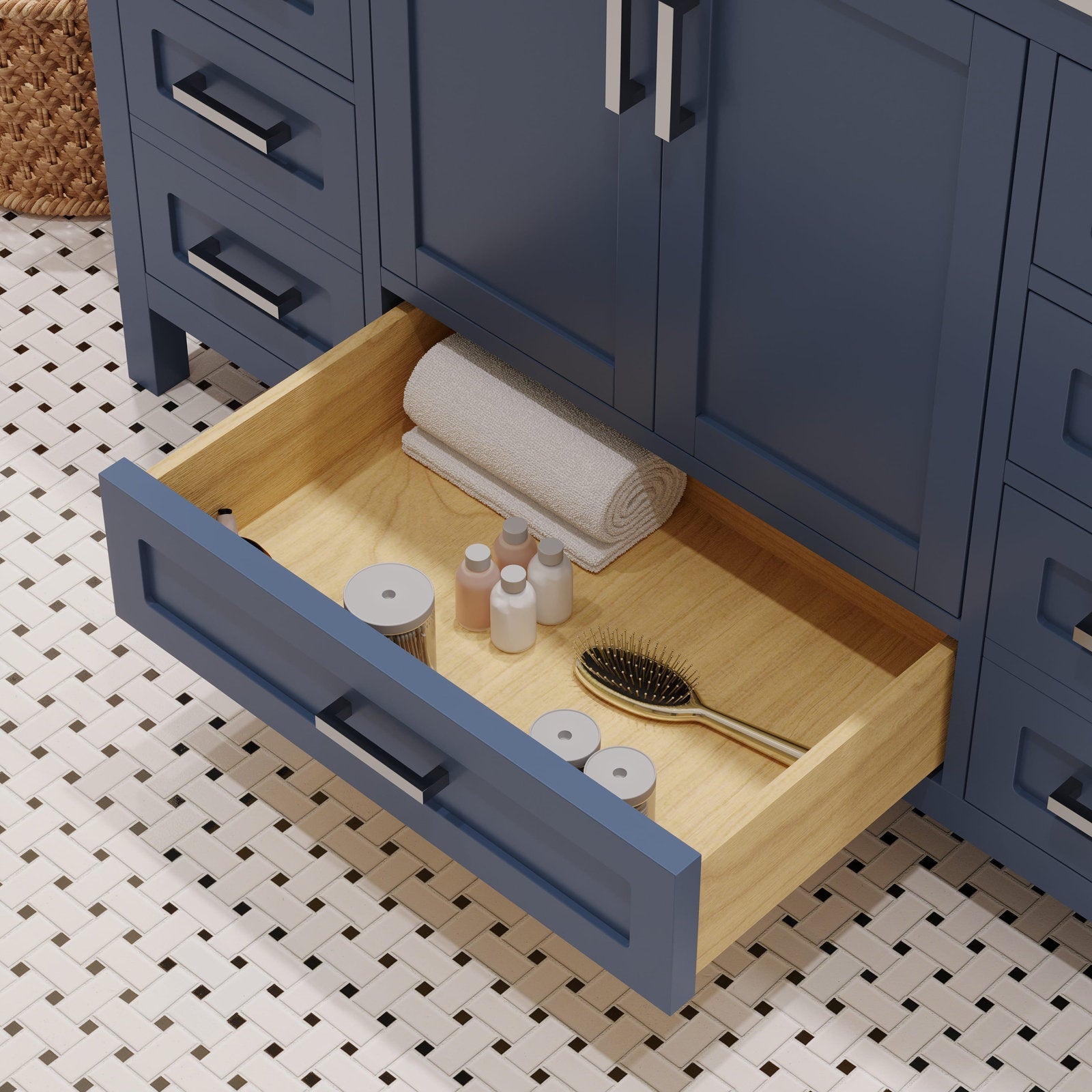 Open stone-finish modern bathroom vanity with a solid wood drawer pulled out to reveal a rolled towel, small toiletry bottles and a gold hairbrush on white mosaic tile flooring.