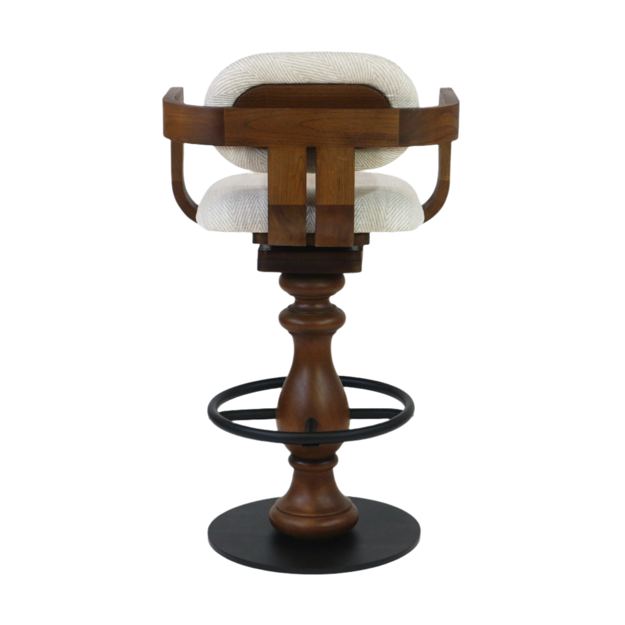 Rear view of a swivel bar stool with light beige fabric upholstery, curved teak wood back and seat frame, turned teak pedestal, black metal ring footrest and round black metal base.