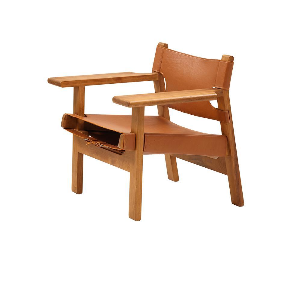 Mid-century modern armchair with a solid teak frame and tan leather sling seat and back, wide flat teak armrests and low-profile legs, with visible leather strap detailing along the front.