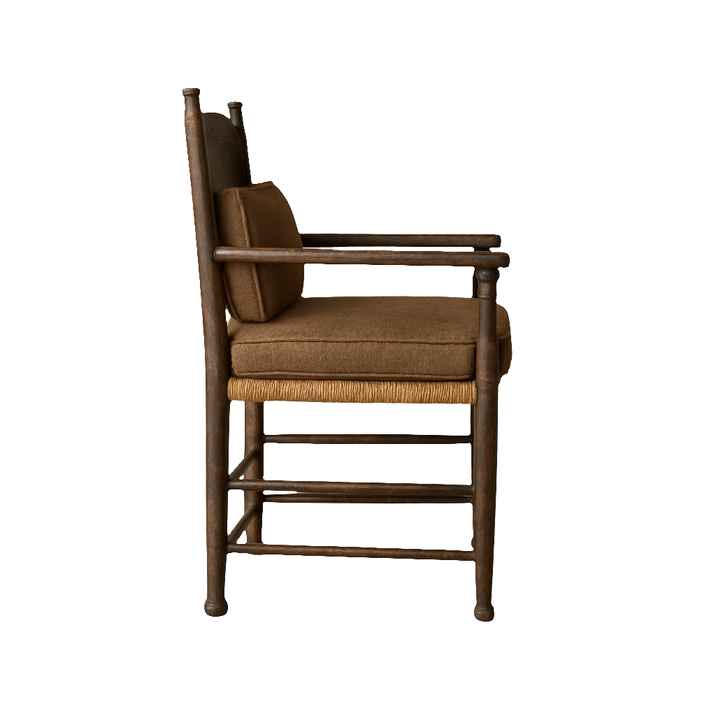 Side view of an Amish-style farmhouse dining chair with dark-stained solid wood frame, woven seat edge, brown fabric seat and back cushions and a matching lumbar pillow, turned legs and wooden armrests.