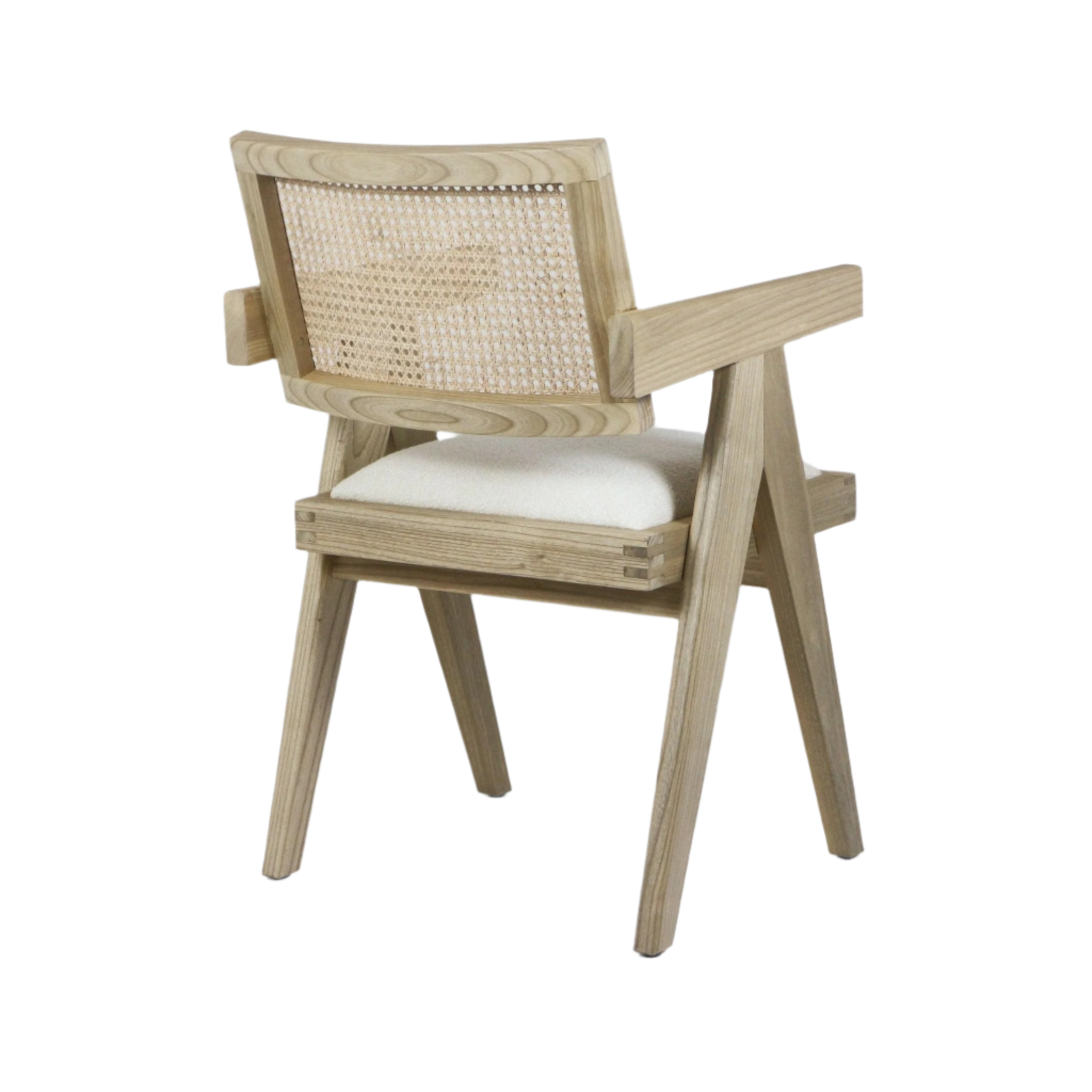 Three-quarter rear view of a natural wood dining armchair with a woven cane back, cream upholstered seat cushion, solid angled legs and straight wooden arms on a white background.