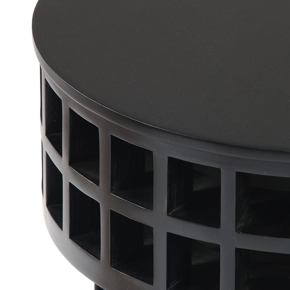 Close-up of a round mahogany-finish black wood side table showing the smooth top and open grid-lattice base with square cutouts, highlighting the modern solid wood construction.