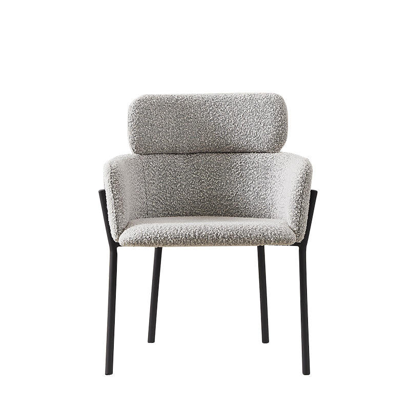 Front-facing modern dining chair upholstered in grey boucle fabric with a rounded padded back and head cushion, curved armrests and slim black metal legs.