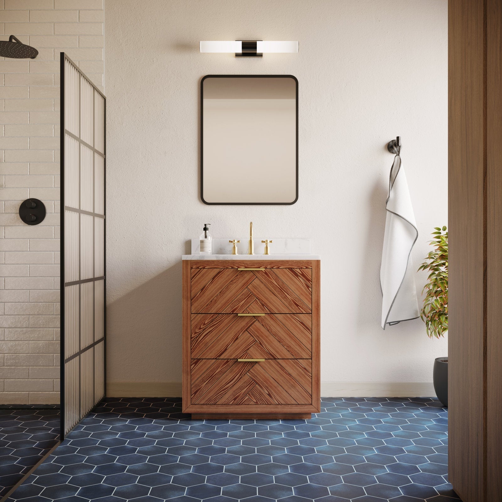 Contemporary 30-inch solid wood single-sink vanity with herringbone drawer fronts, white stone countertop, brass faucet and pulls, paired with a rounded-rectangle mirror, wall sconce, towel hook, shower screen and dark hex tile floor.