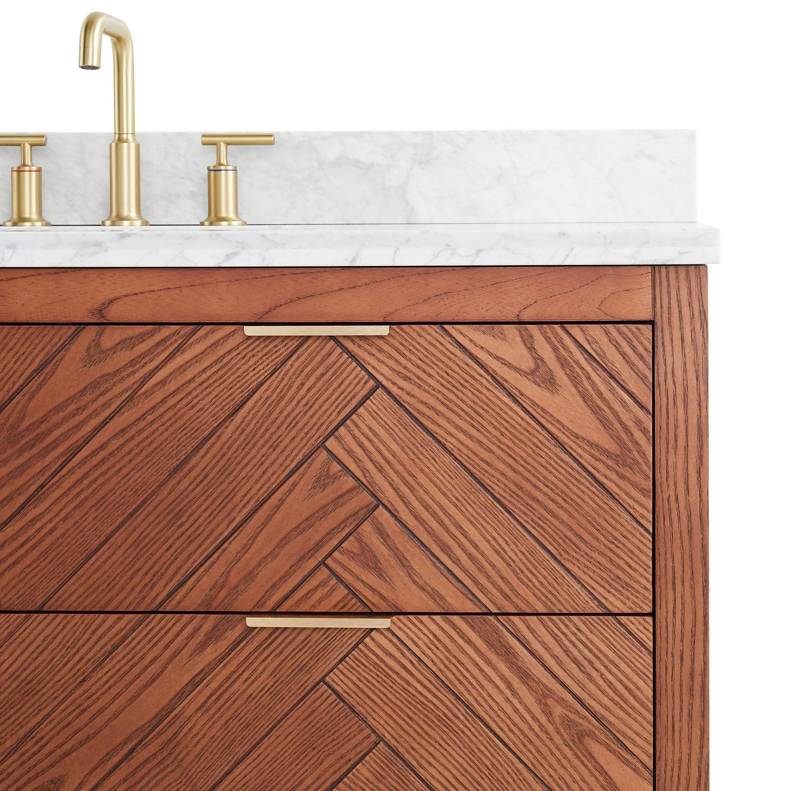 Close-up of a modern solid-wood vanity with herringbone drawer fronts, white stone countertop and slim brass faucet and drawer pulls.