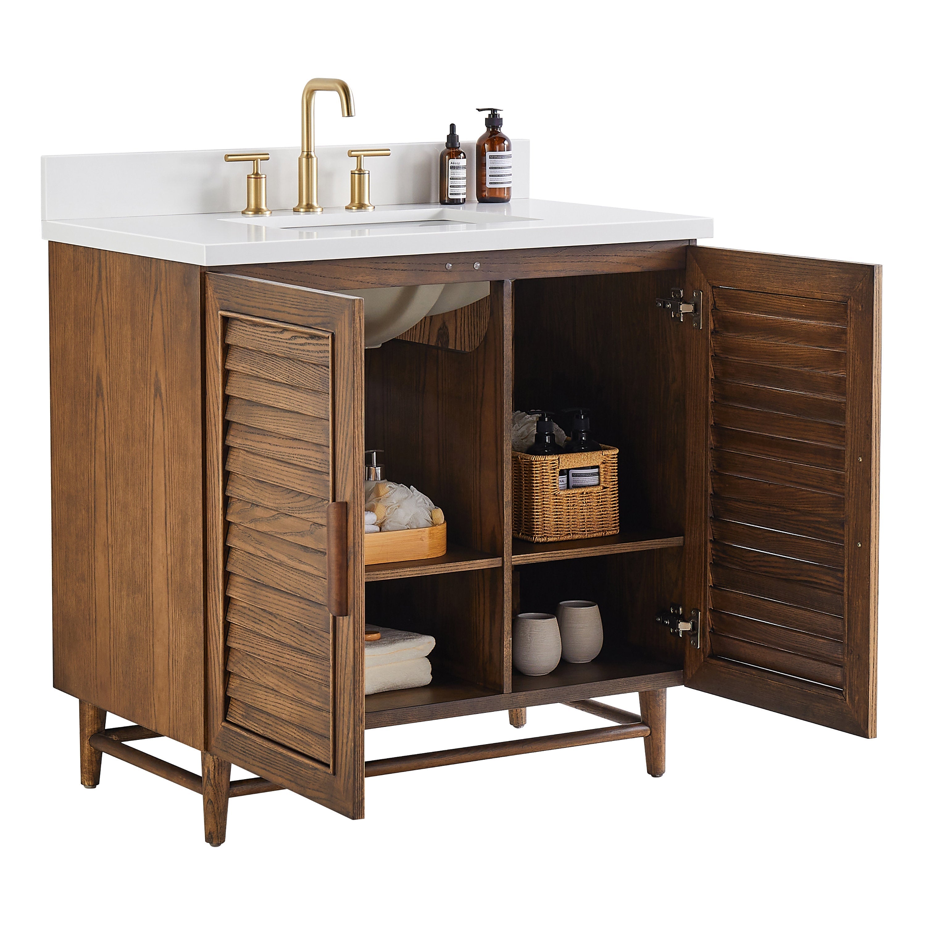 36-inch walnut bathroom vanity with a white quartz top, rectangular undermount sink and gold-tone widespread faucet; louvered double doors open to four interior cubbies staged with a wicker basket, towels and bath accessories.