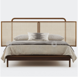 Three-panel woven rattan cane headboard on a teak platform bed with a rounded top rail, dressed in neutral linen bedding and a patterned lumbar pillow on a white studio background.