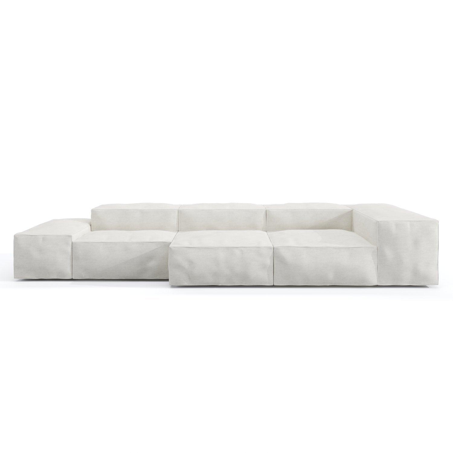 Low-profile modular sofa upholstered in loose white linen with deep cushioned block seats, wide low arms and a subtle wooden base, shown against a plain white background.