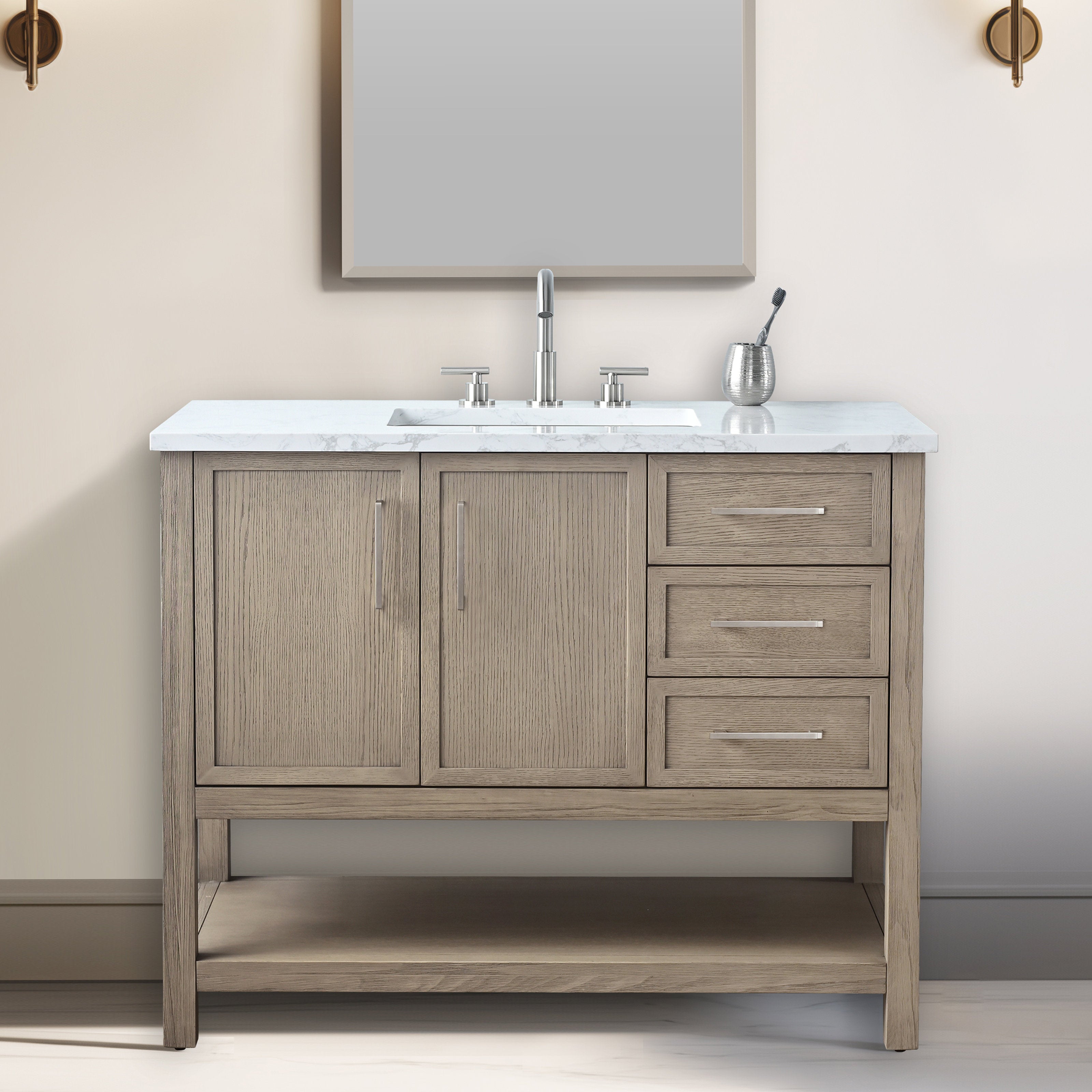 Modern light stone-finished solid wood bathroom vanity with white marble top, undermount sink and brushed nickel faucet, two paneled doors left, three drawers right, open bottom shelf and slim metal handles.