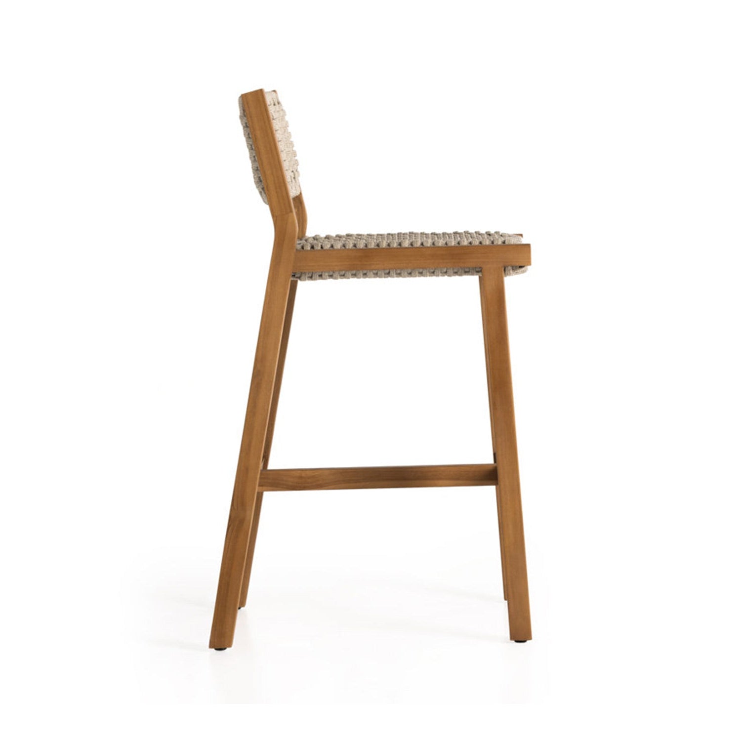 Side view of an armless outdoor bar stool in natural teak with a solid wood frame, woven neutral-fiber seat and low woven back showcasing a coastal, mid-century inspired silhouette.