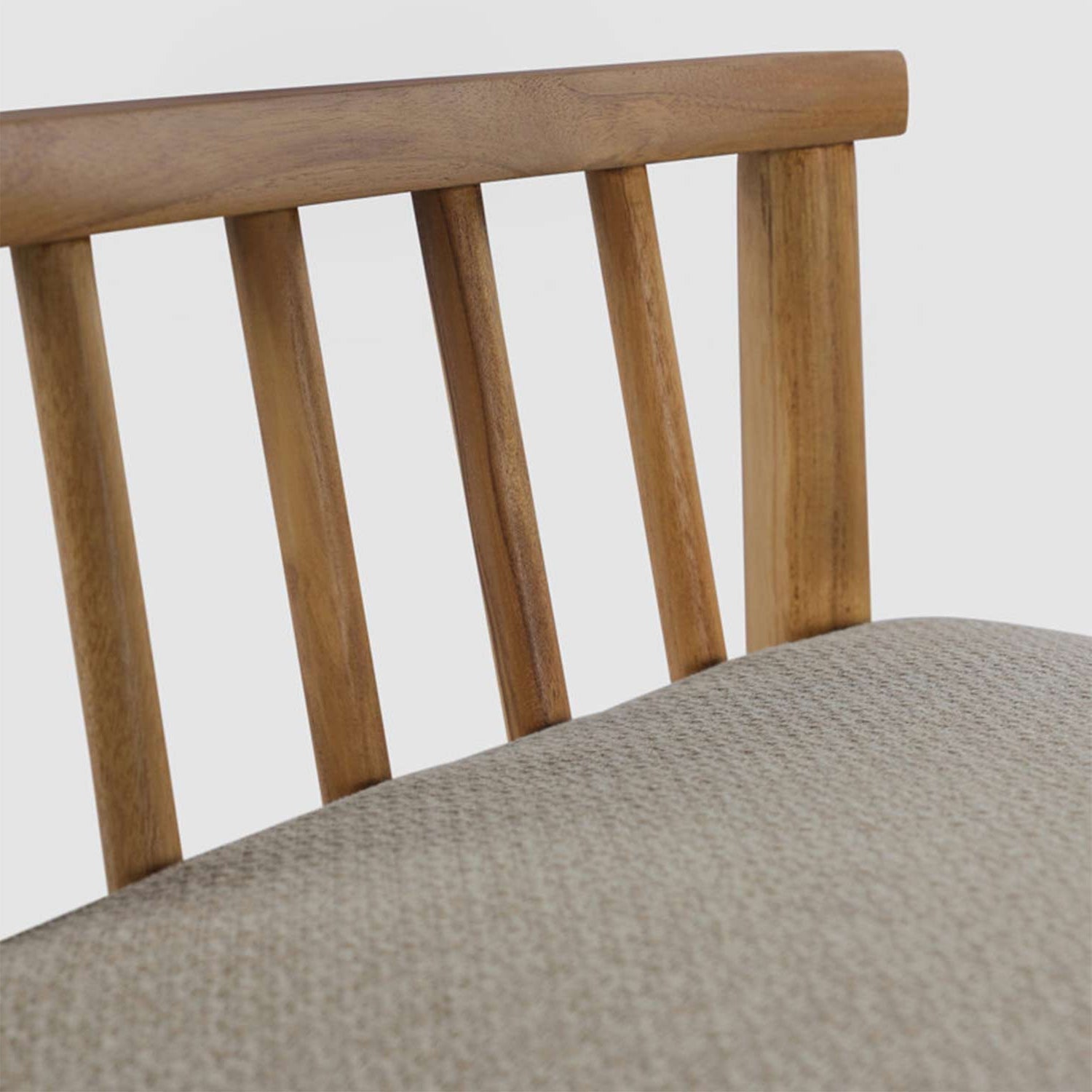 Close-up of a teak slatted backrest and light beige textured upholstered seat on an armless outdoor bar stool, shown against a neutral background.