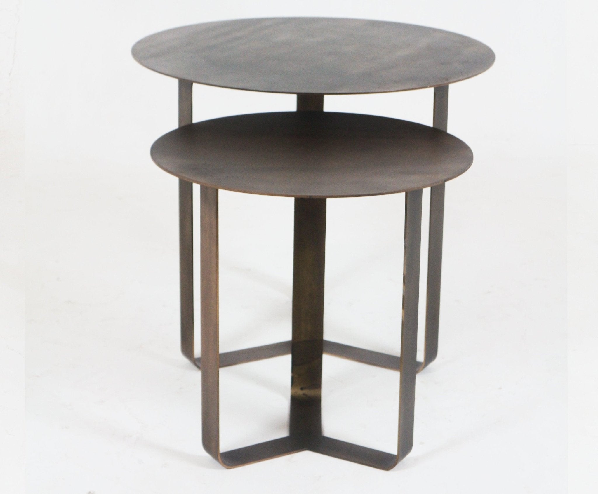 Set of two modern floating bronze metal nesting side tables with thin round tabletops and geometric looped legs, photographed stacked on a white background.