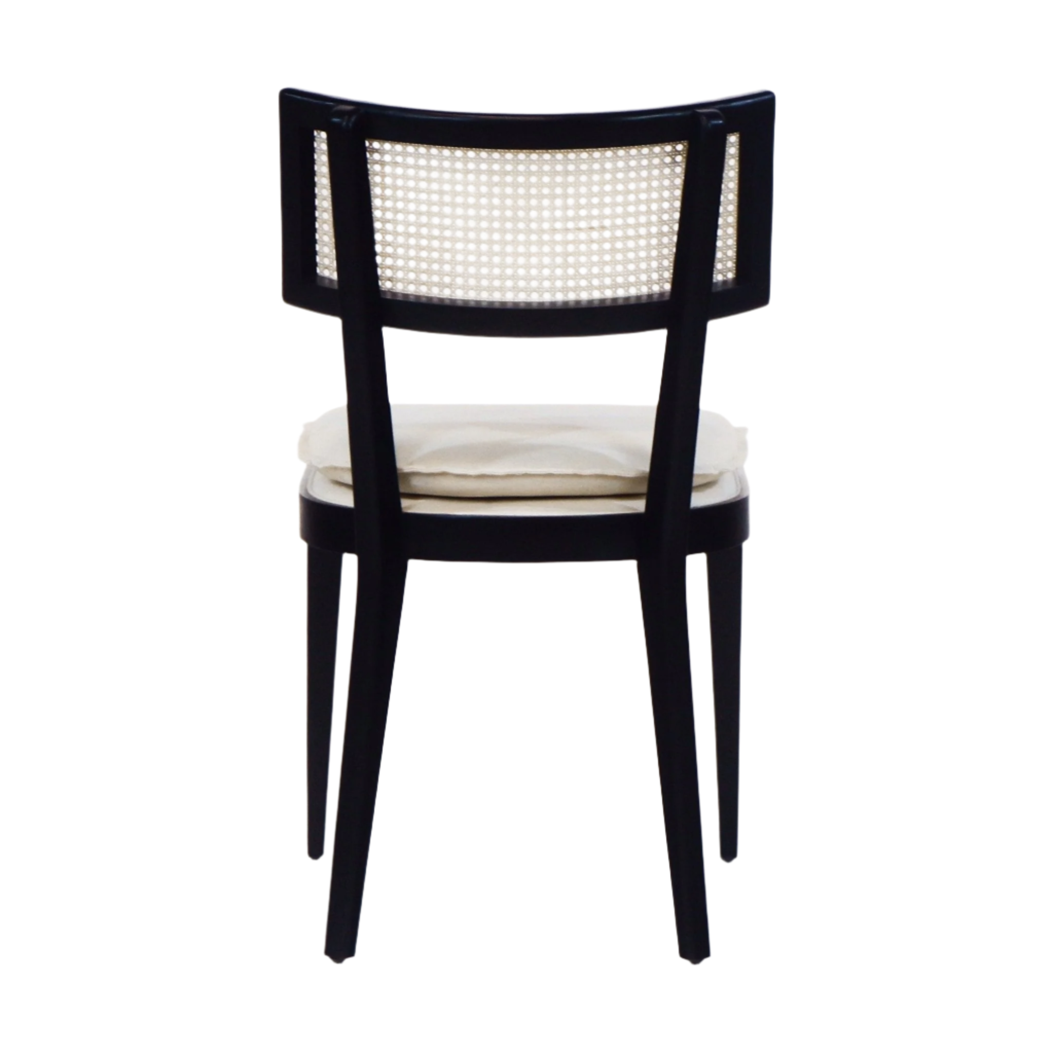Rear view of a black wooden dining chair featuring a woven rattan backrest and a cream upholstered seat cushion with tapered legs.