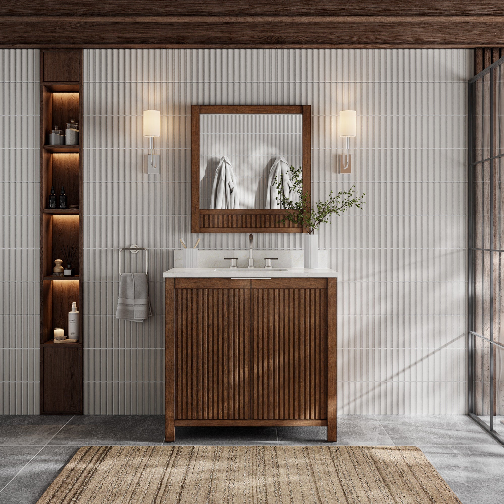 Freestanding modern bathroom vanity in warm solid wood with vertical fluted doors, a stone top with integrated single sink, framed wood mirror, twin wall sconces, recessed lit shelving and towel ring.