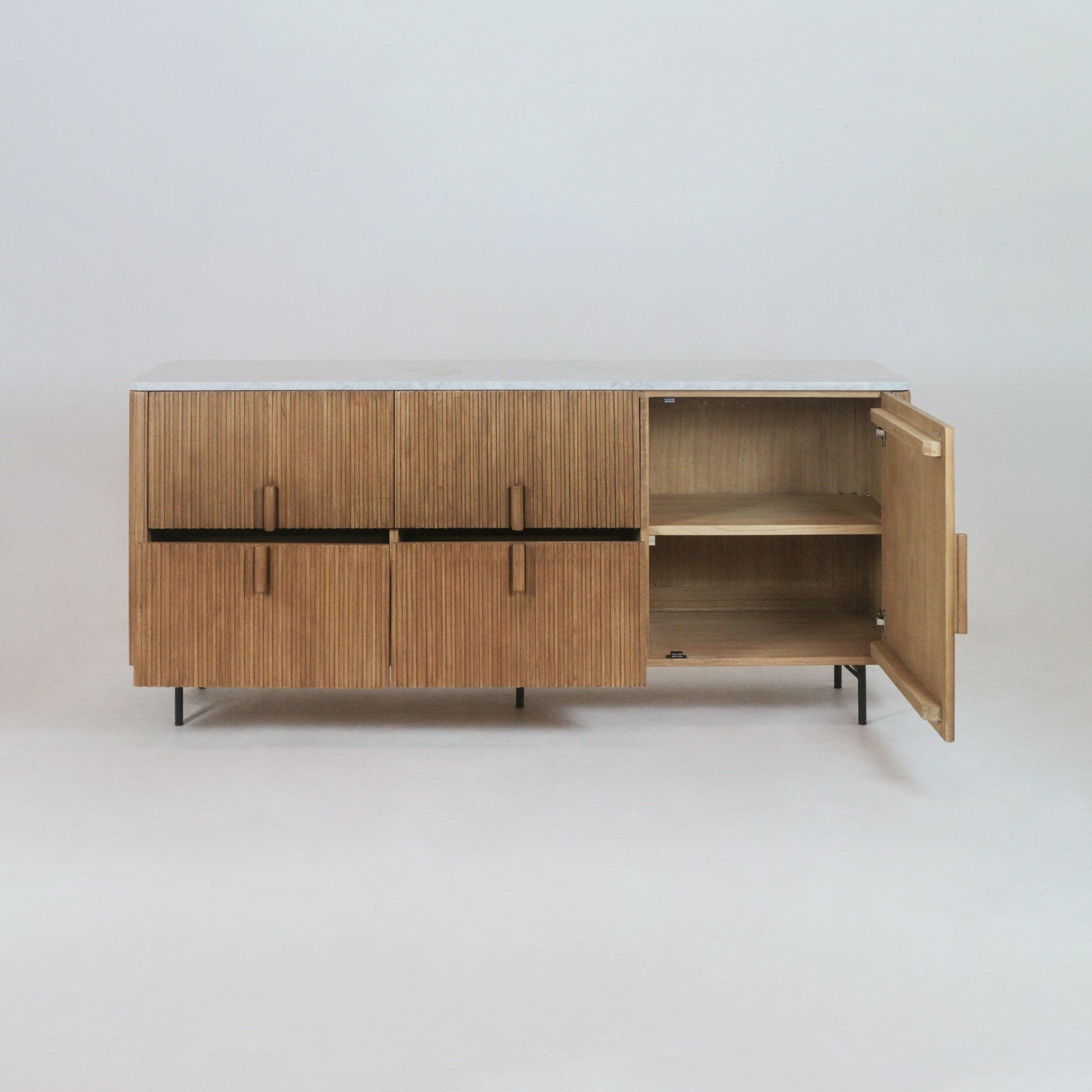 Teak sideboard with vertical fluted doors, white marble top and slim black metal legs, shown with the right door open to reveal two interior shelves in a mid-century modern style.
