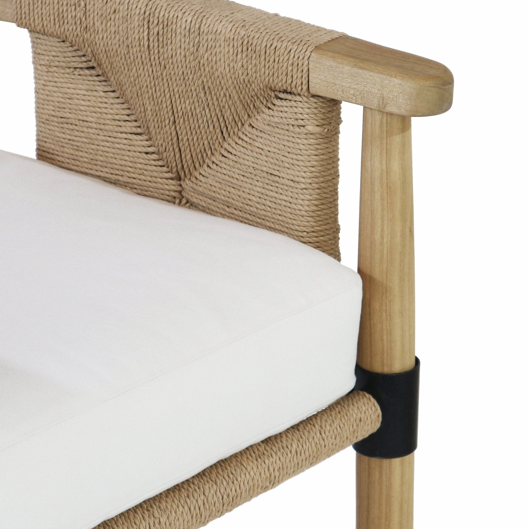 Close-up of a natural teak arm and leg with a woven natural rope back, white fabric seat cushion, and a black metal collar detail on the leg.