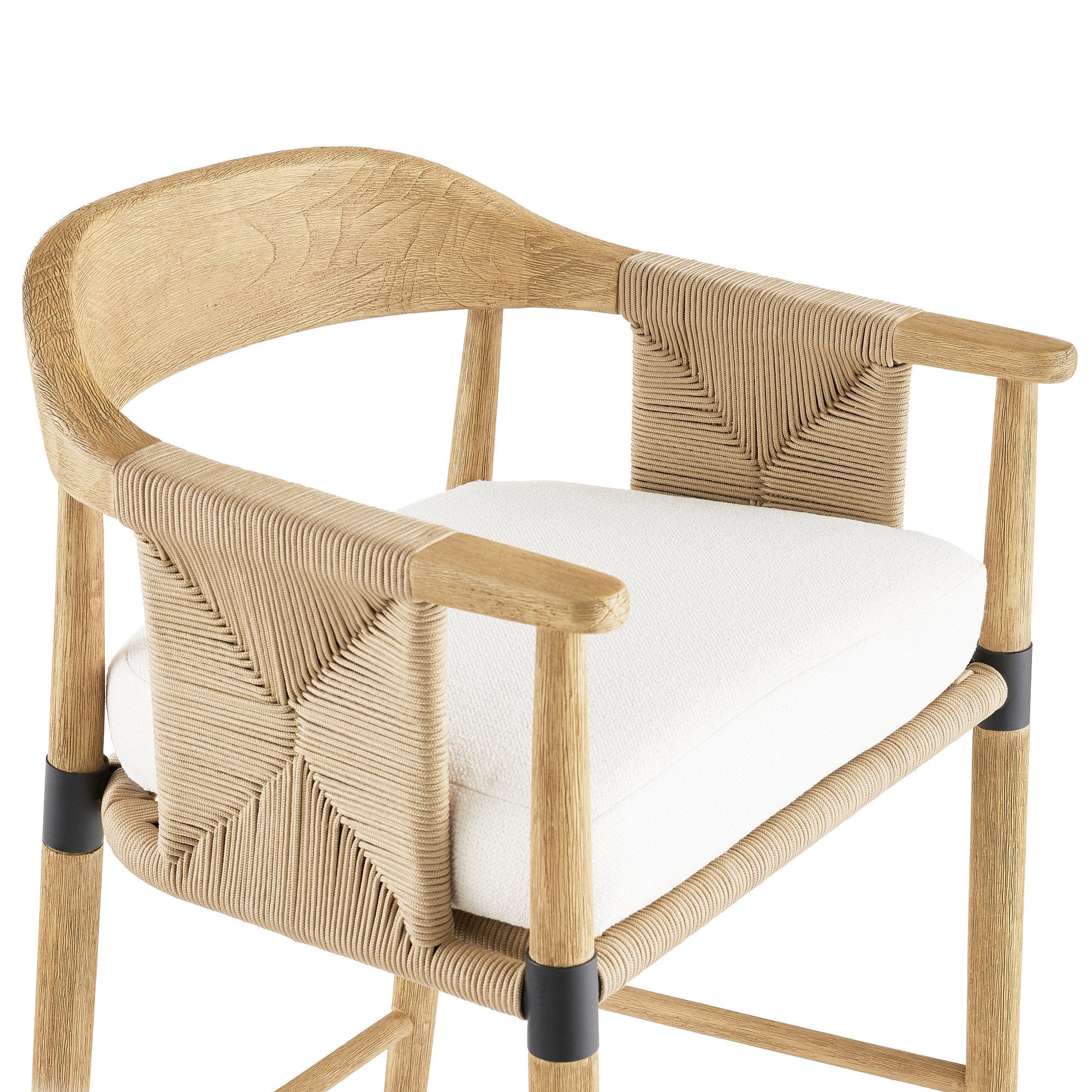 Close-up of a natural wood bar stool featuring a rope-woven back, curved oak arms, a white upholstered seat cushion and black metal leg collars.