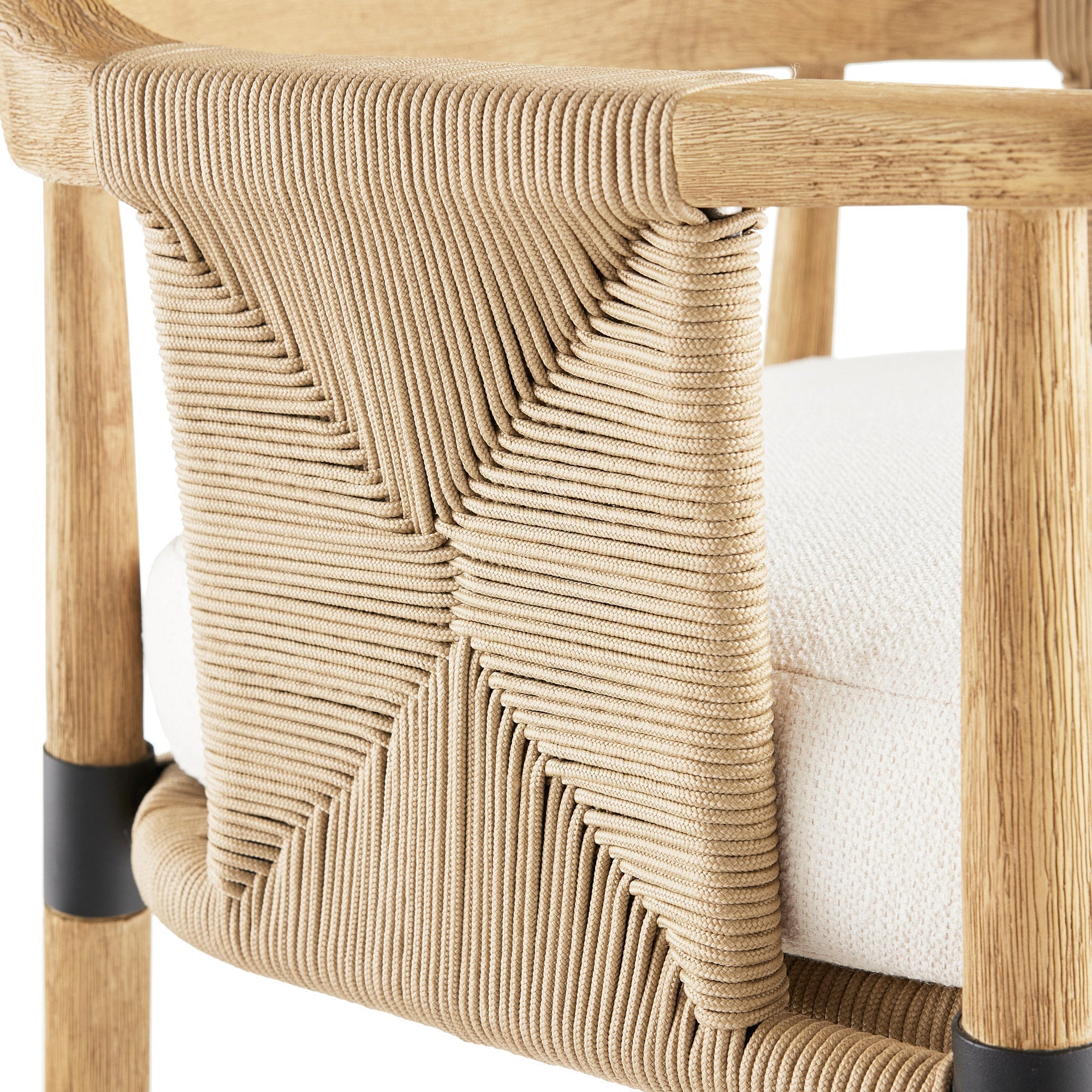 Close-up of a natural oak stool showing a tightly woven tan rope backrest, off-white upholstered seat cushion, and a black metal ferrule on the leg.