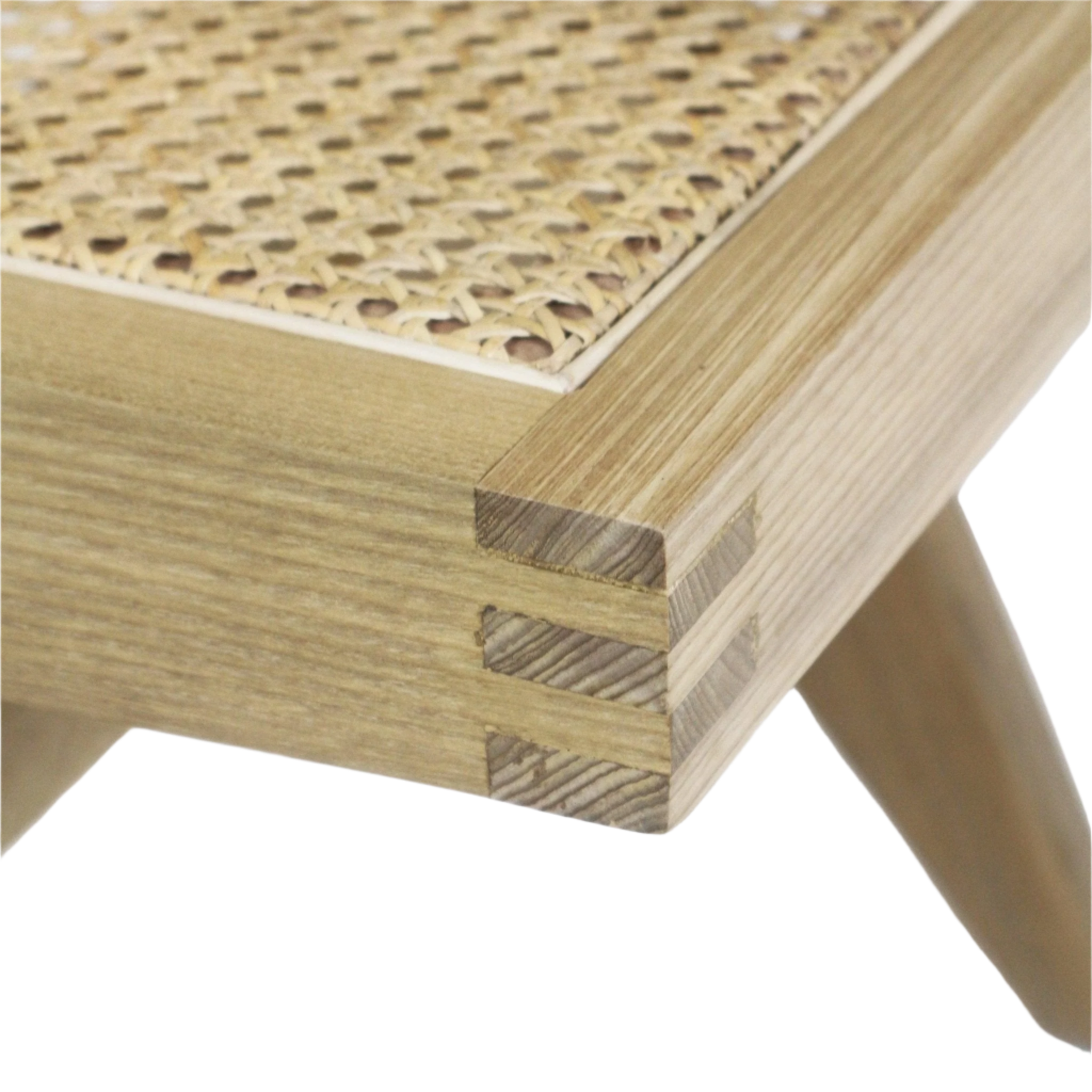 Close-up of a natural blonde solid wood chair corner showing finger-joint construction, tapered leg and a woven Vienna cane seat insert.