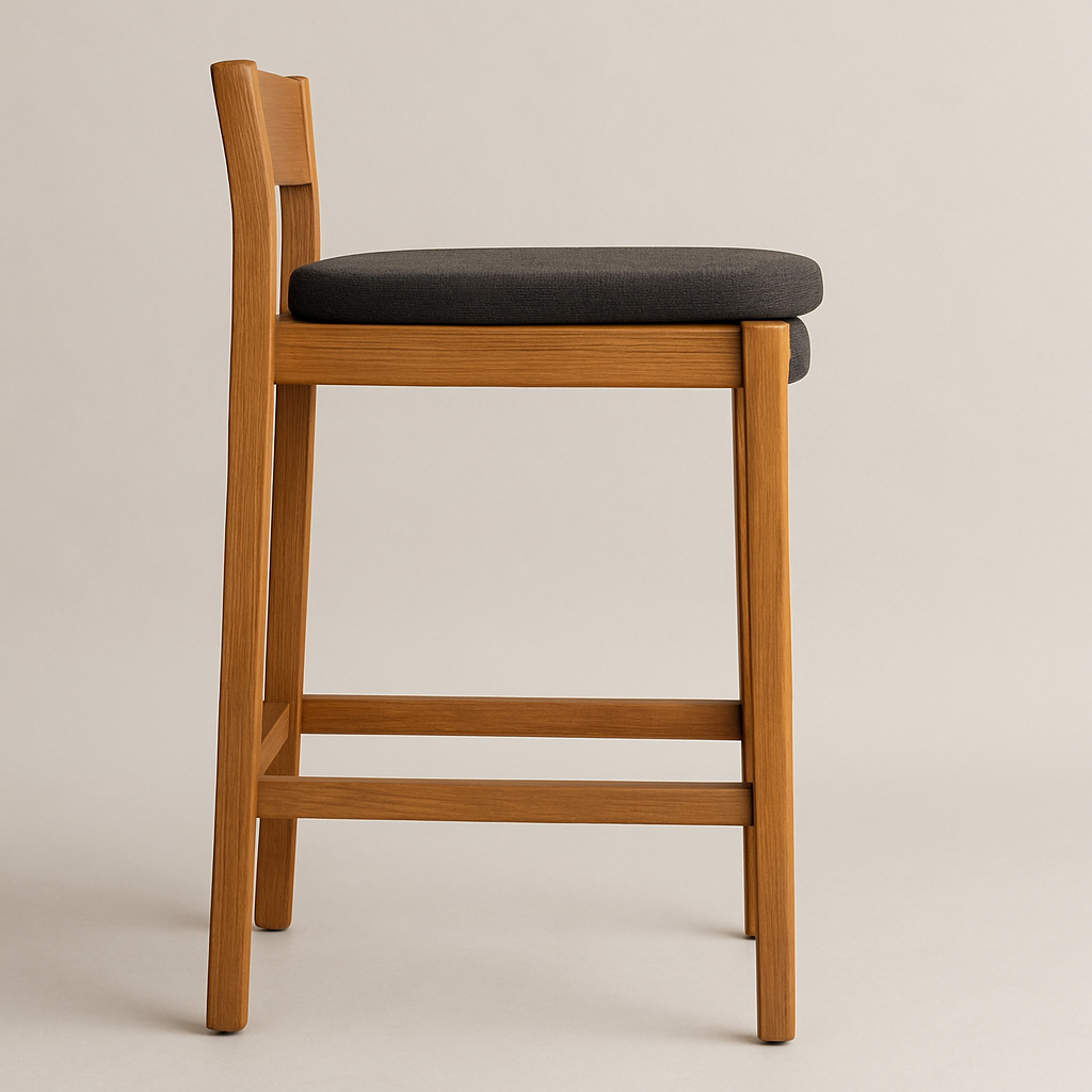 Side view of an armless outdoor bar stool with a natural teak frame and gray upholstered fabric seat, tapered legs and horizontal footrest in a contemporary coastal style.