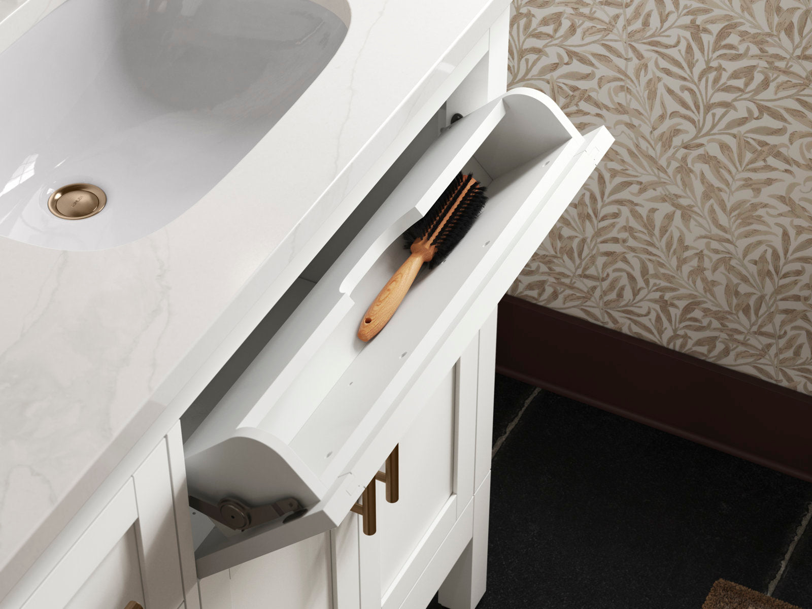 Close-up of a modern stone-top bathroom vanity with white integrated sink, brass drain and gold-tone hardware; slim white pull-out wooden drawer is open showing a wooden-handled brush inside.