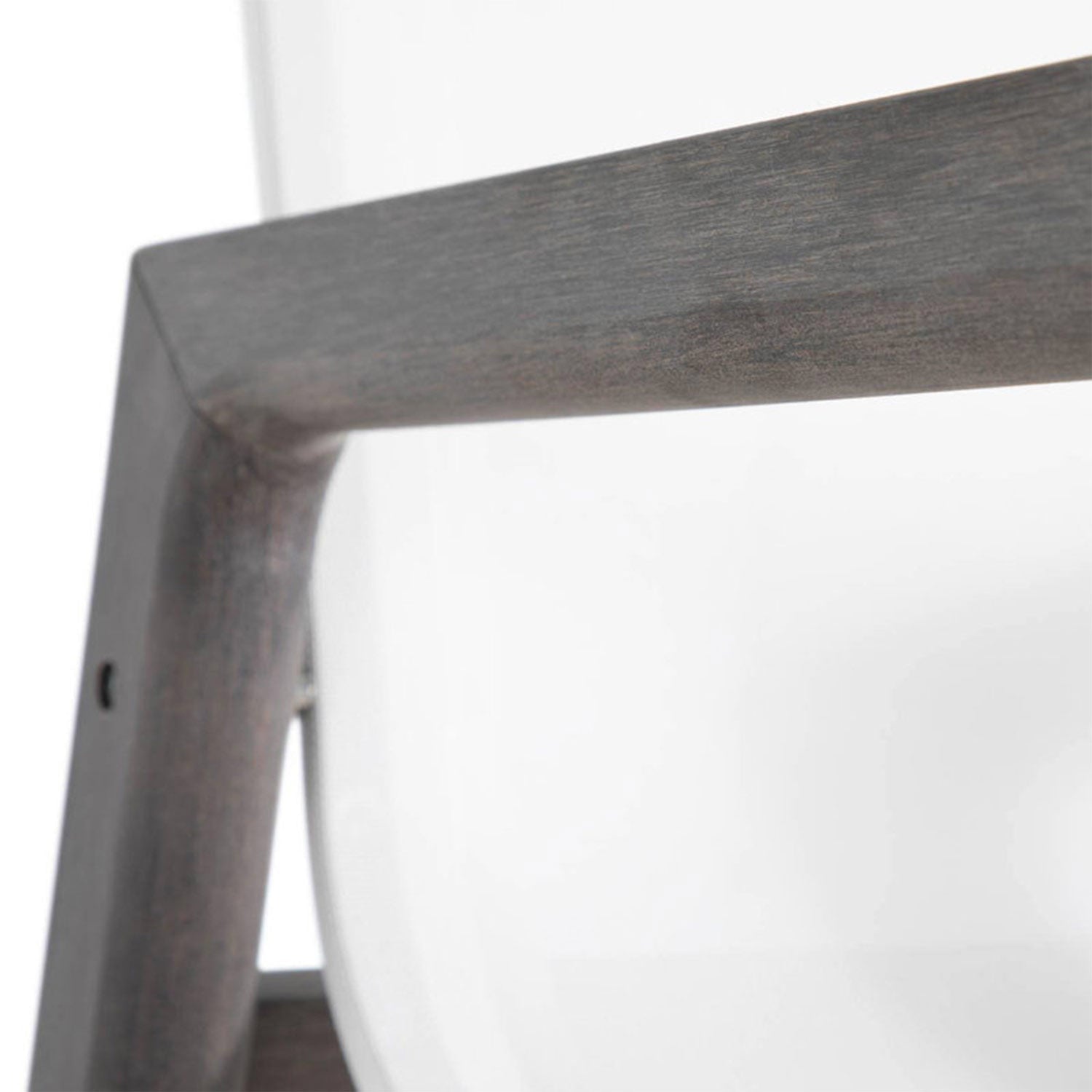 Close-up of a teak wood frame corner and curved white molded seat on a coastal outdoor bar stool, showing natural teak grain and the smooth seat edge.