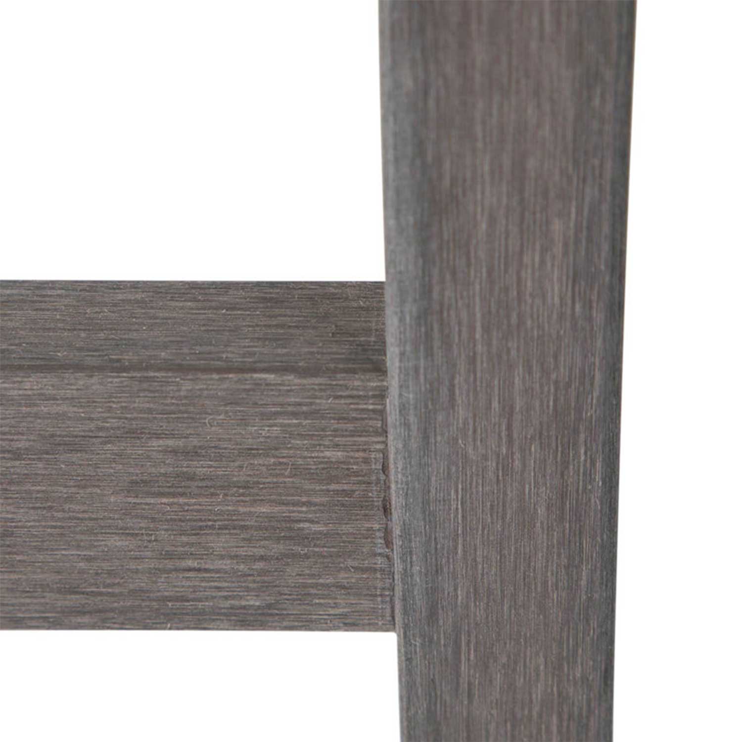 Close-up of a teak bar stool leg and horizontal rung showing textured natural teak wood grain and a weathered teak finish at the joint.