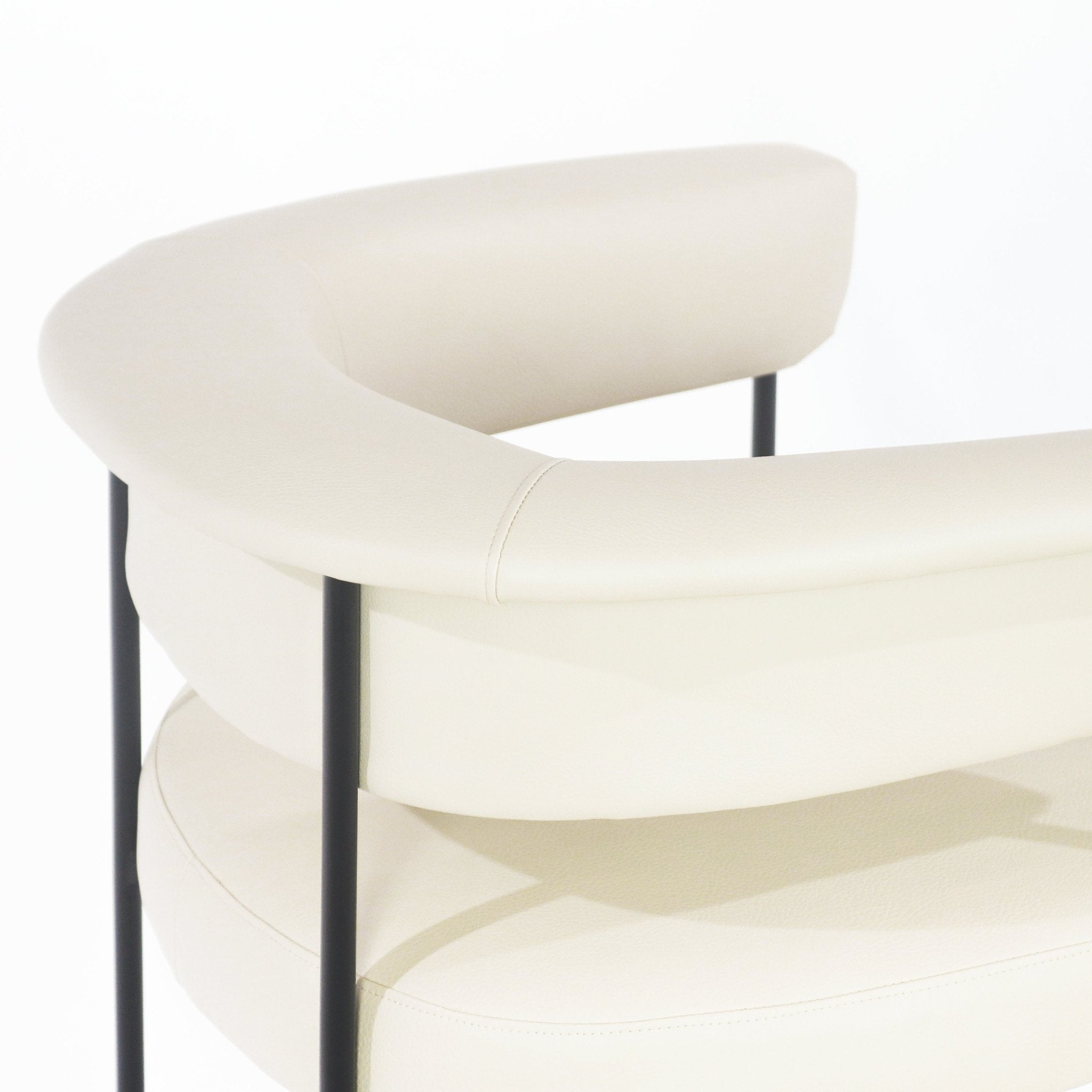 Close-up of a modern cream faux leather counter stool showing the curved padded backrest with visible stitching and slender black metal support rods.