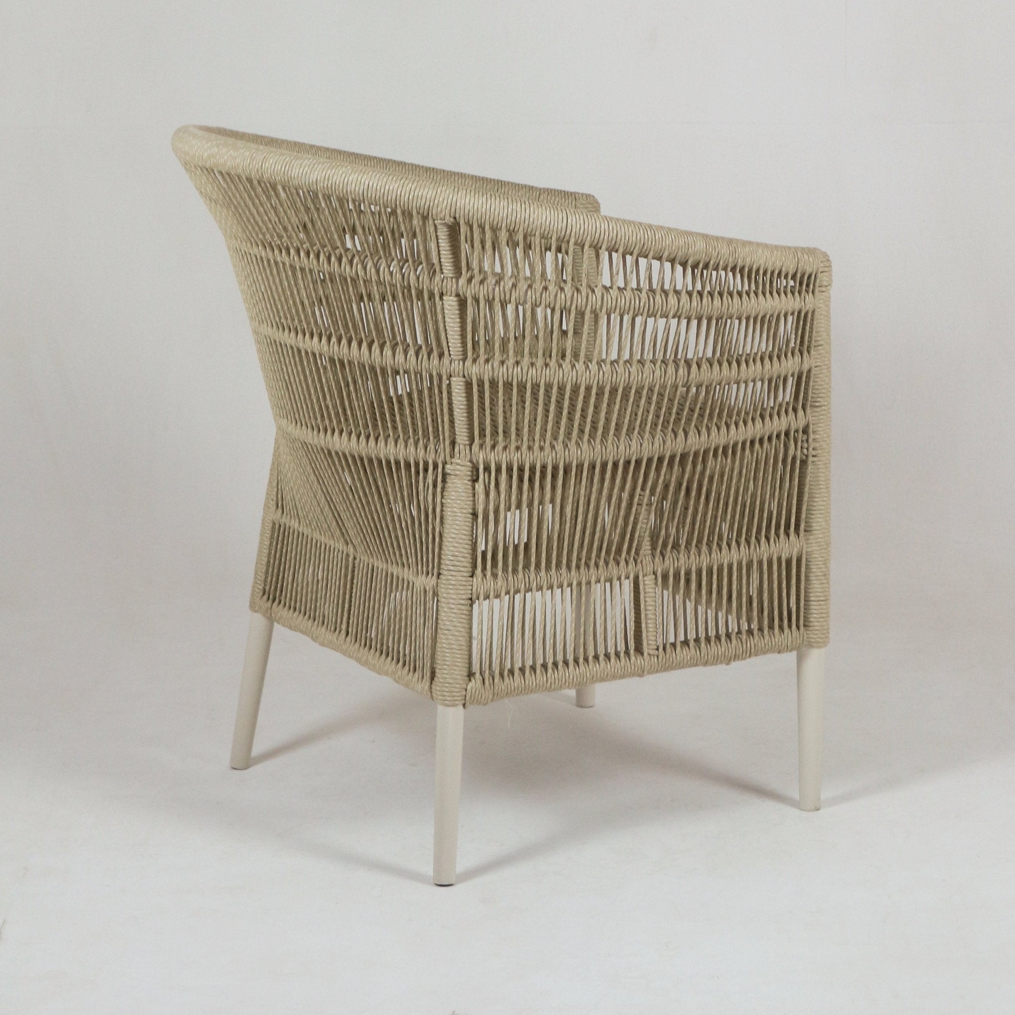 Back and side view of a coastal beige rope-woven outdoor chair with open woven back, rope-wrapped frame and slender white metal legs.