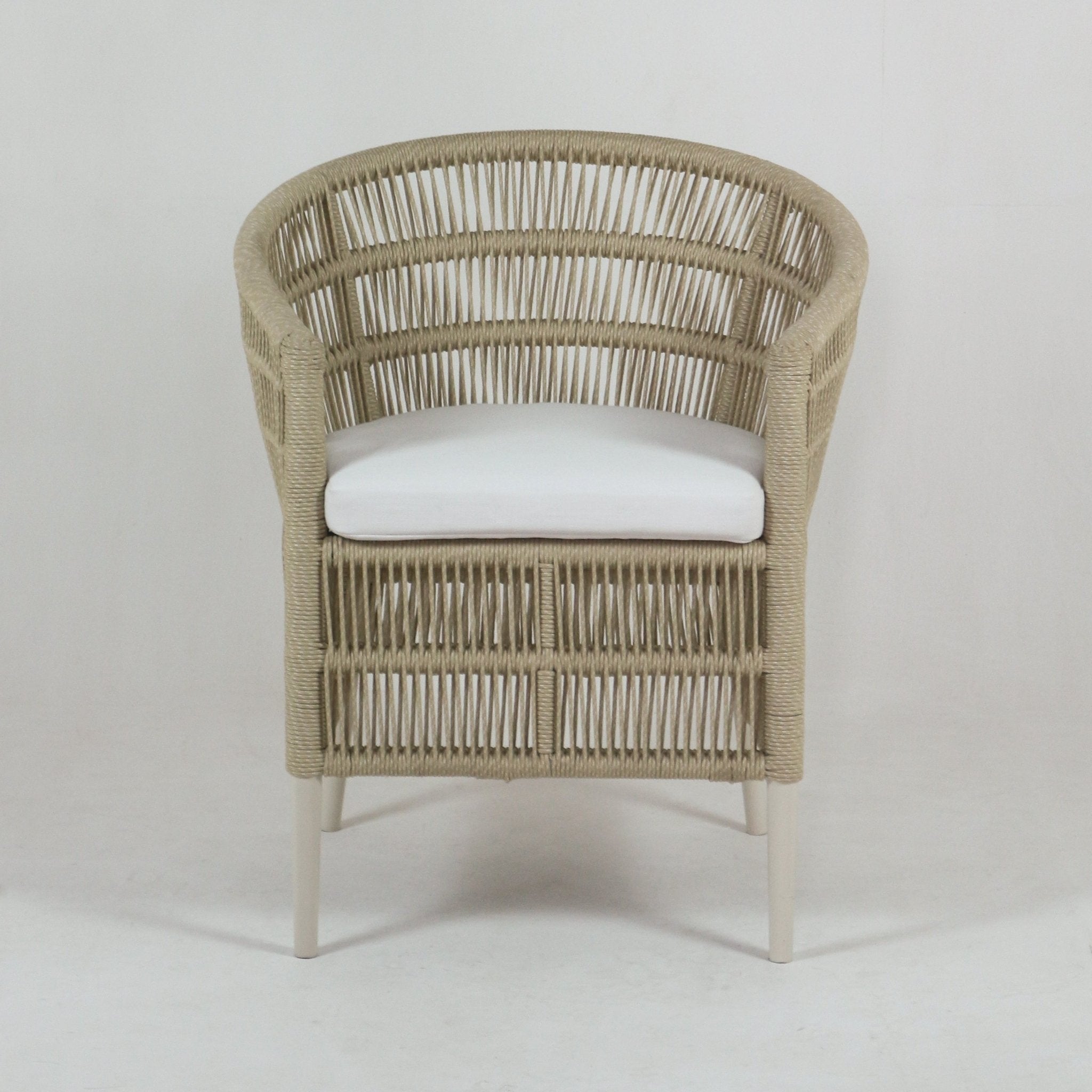 Front view of a coastal-style outdoor chair with a beige rope-woven frame, white cushioned seat and slim white metal legs.