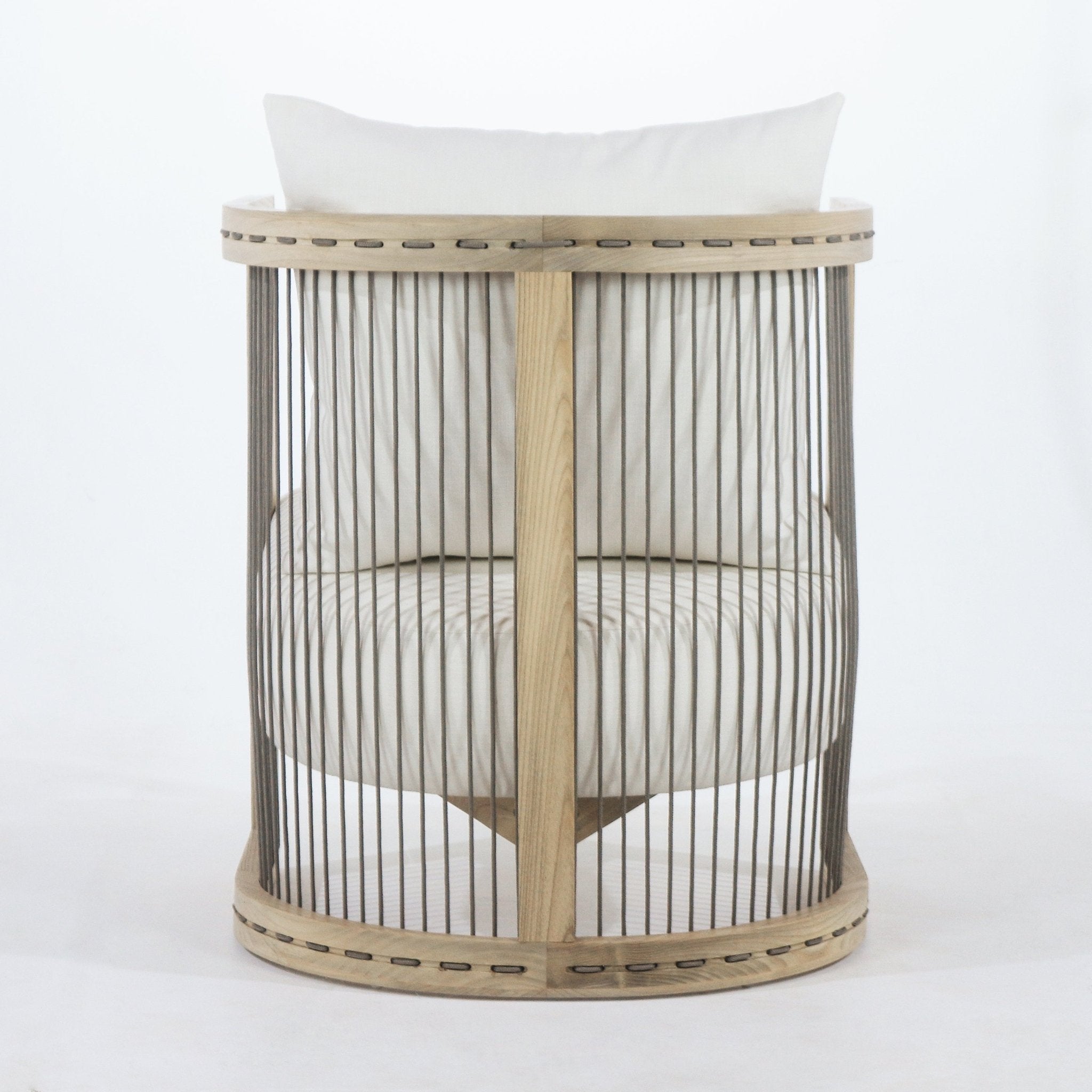 Front view of a round dining chair with a light natural wood circular frame and vertical dark rope cord slats enclosing an off-white fabric seat cushion and matching back pillow.