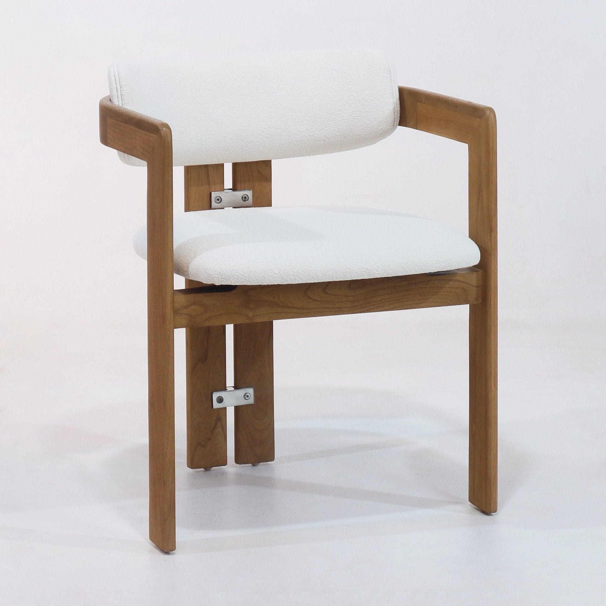 White bouclé-upholstered dining chair with a teak wood frame, curved armrests, open-back support and visible stainless metal brackets, shown on a plain white background.
