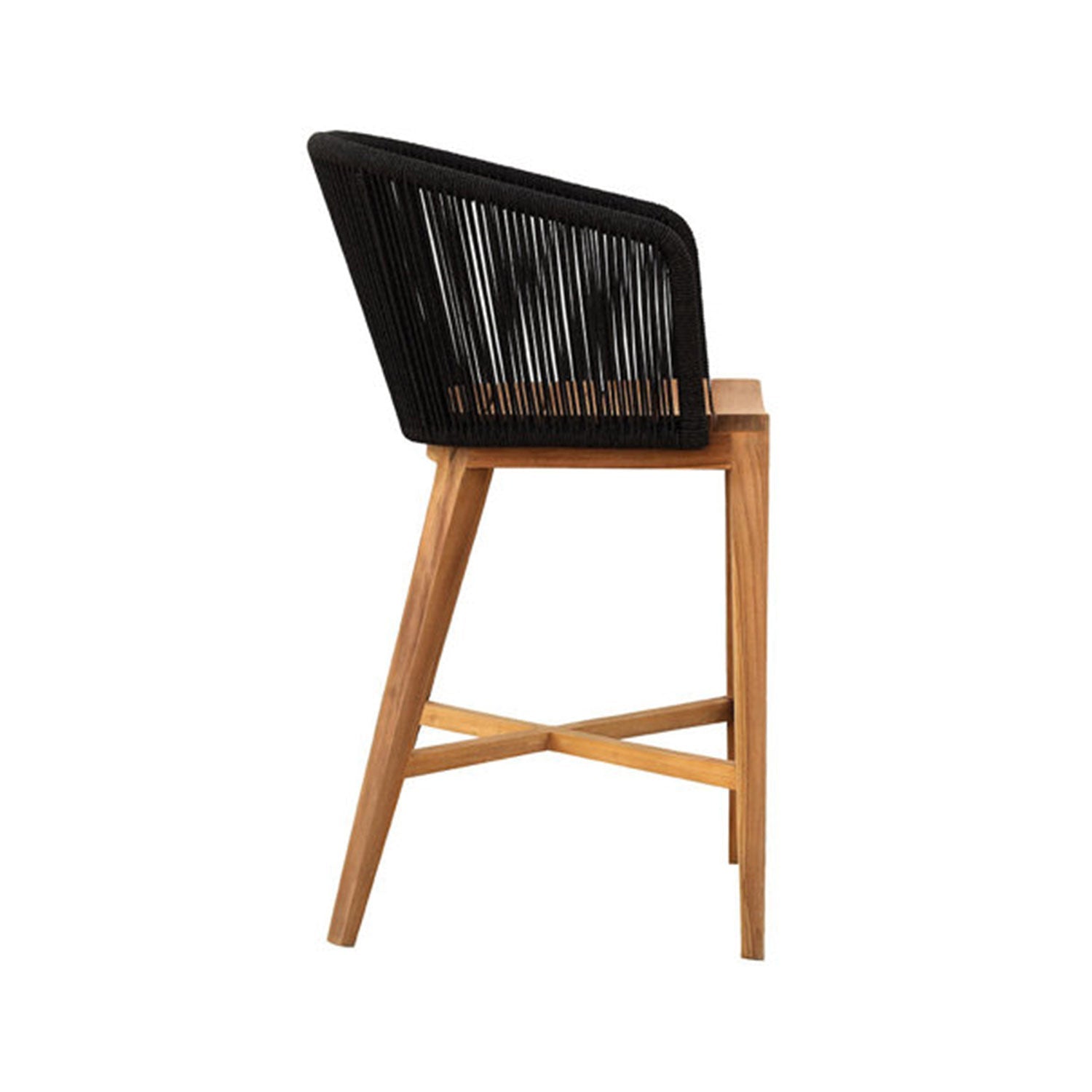 Side profile of a teak outdoor bar stool with a natural wood frame, angled legs, X-shaped cross-braced footrest and a black woven rope backrest.