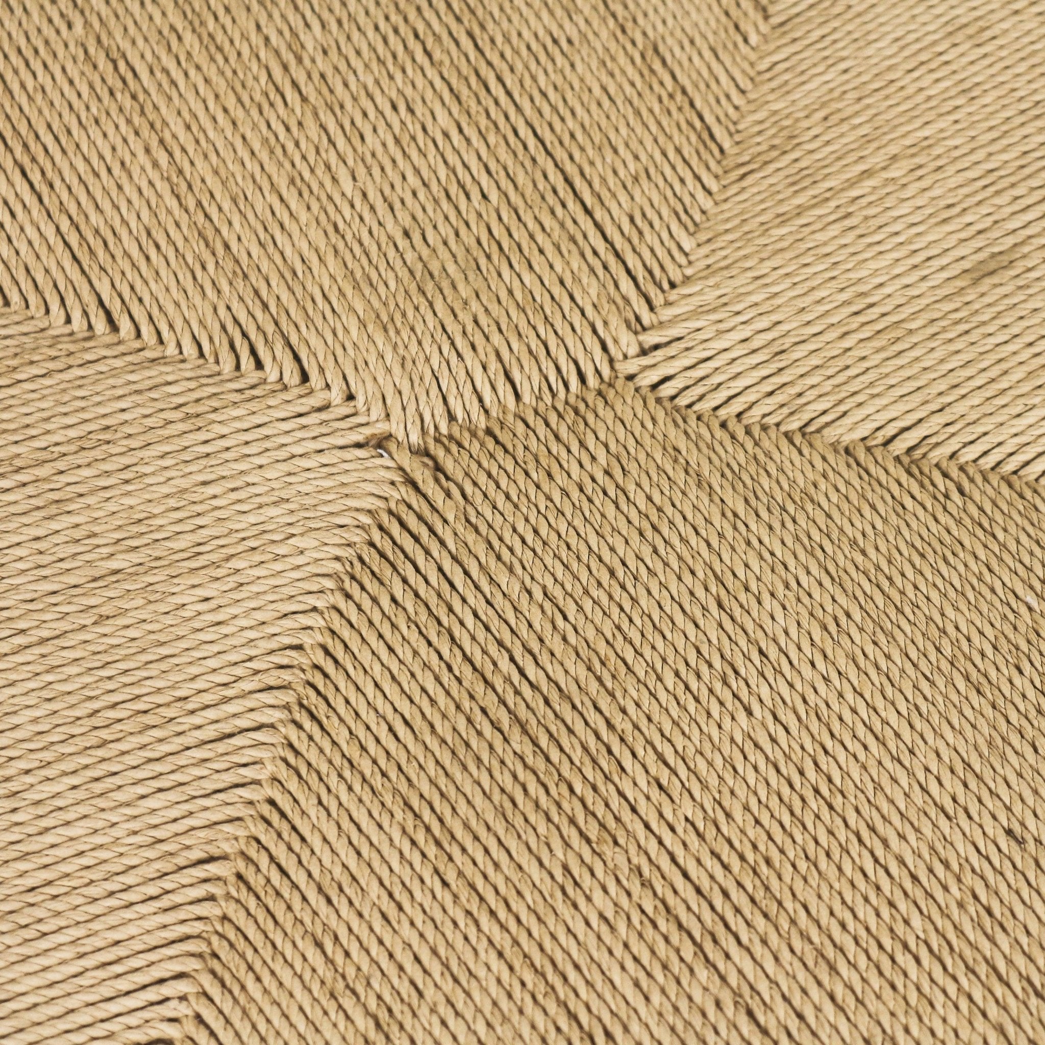 Close-up of a natural seagrass woven dining chair seat showing a square pattern of tightly twisted beige rope fibers and pronounced handwoven texture.