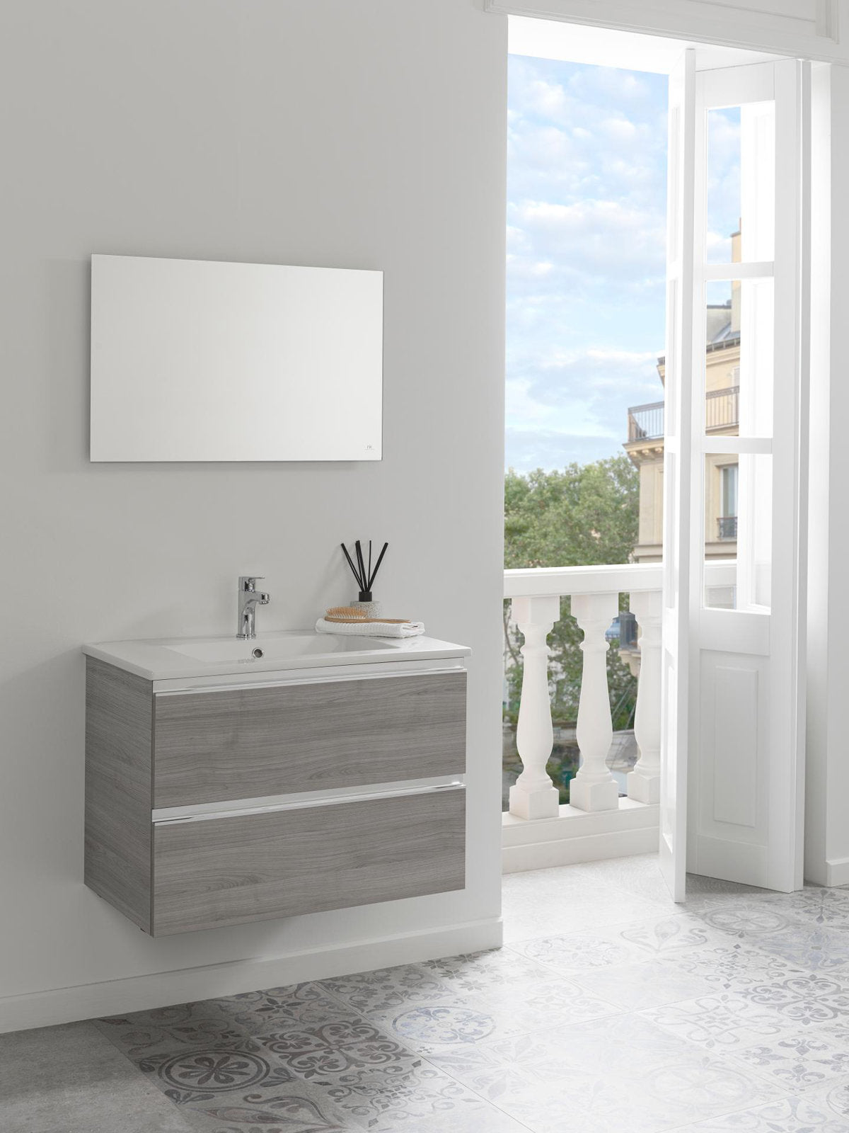 Floating modern single-sink bathroom vanity in stone-colored solid wood with a white stone top, two horizontal drawers and chrome faucet; rectangular mirror above, reed diffuser and towel on top by an open balcony.
